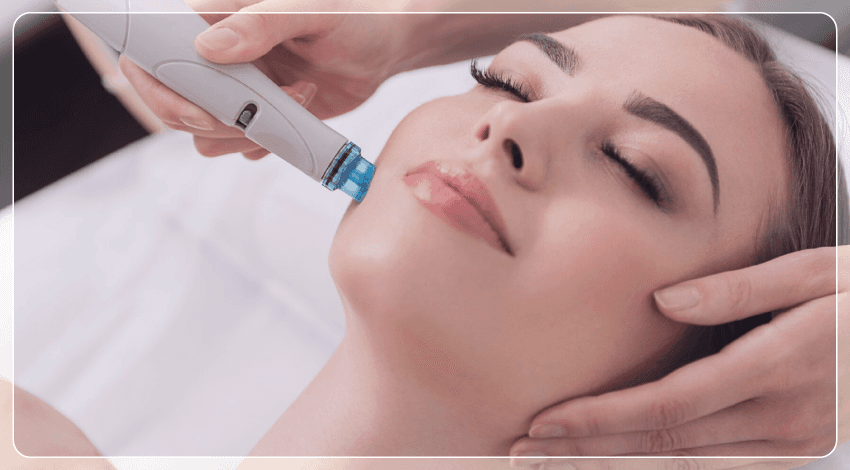 A woman lying down with a towel wrapped around her head, her face glowing with facial oil. She has a peaceful expression, enjoying a skincare treatment.