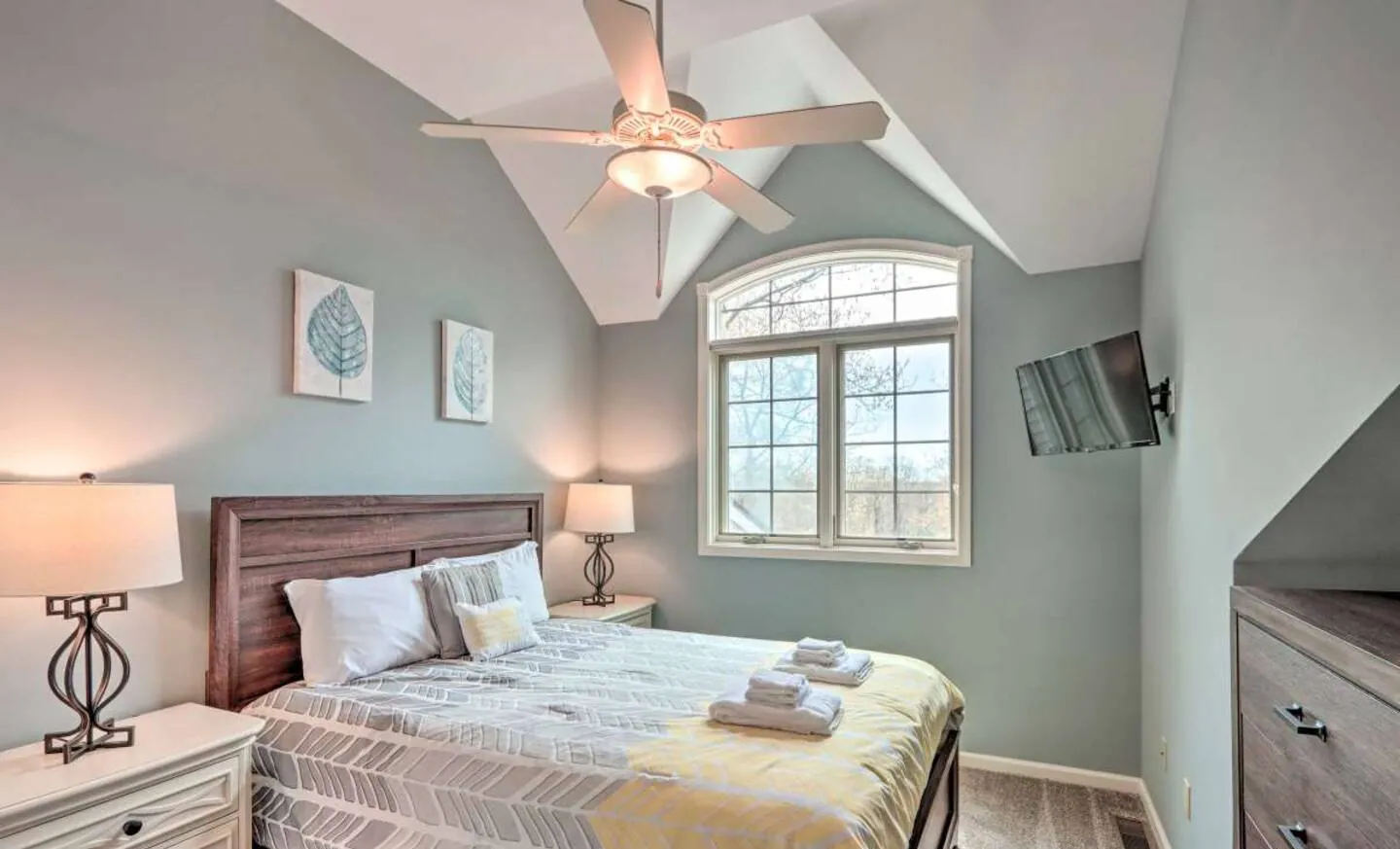 Upstairs queen bedroom with arched window, wood headboard and wall TV at SummitWind