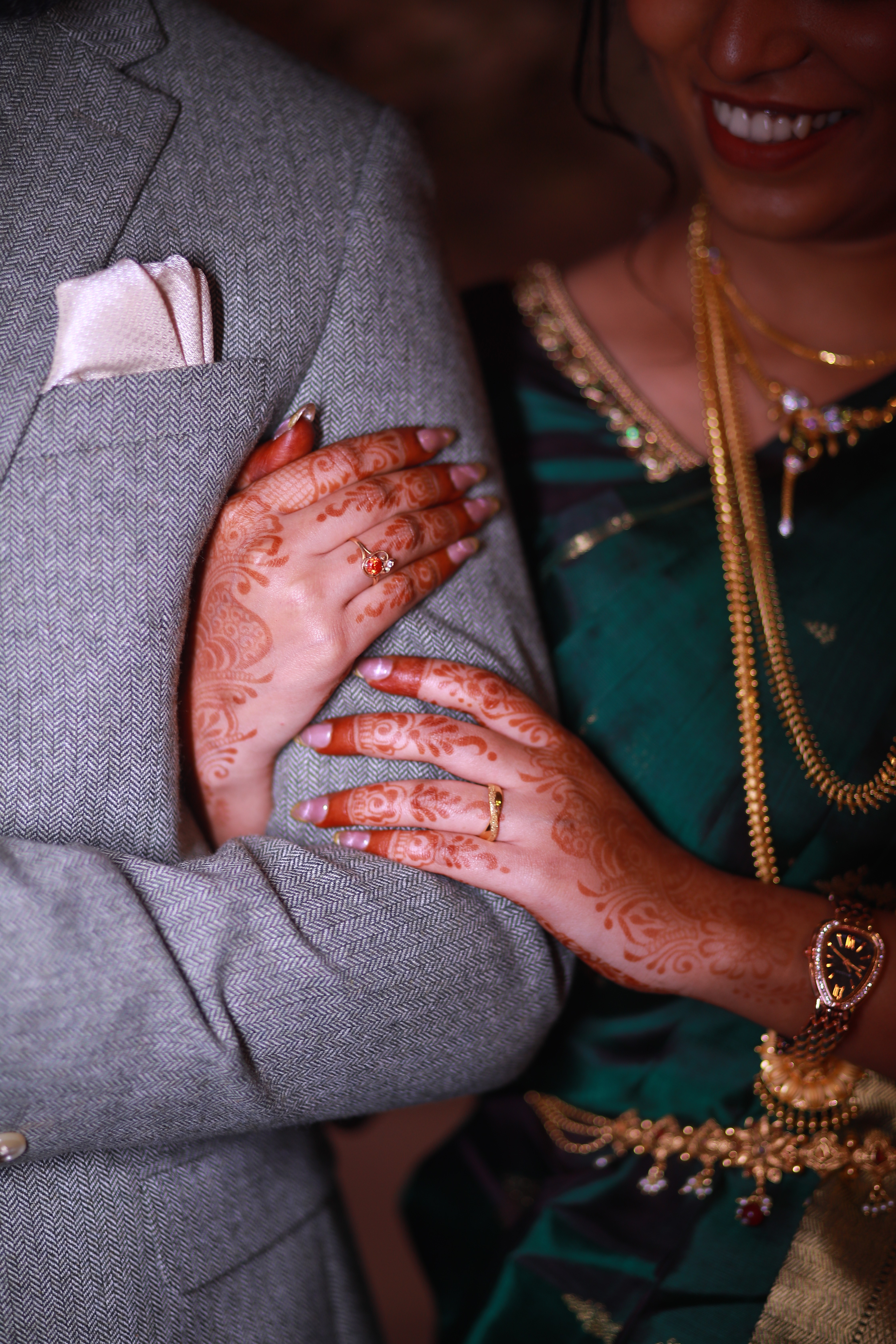 A bride and groom share a kiss, enveloped in the bride's flowing veil. The soft focus and gentle light convey a romantic, intimate atmosphere.