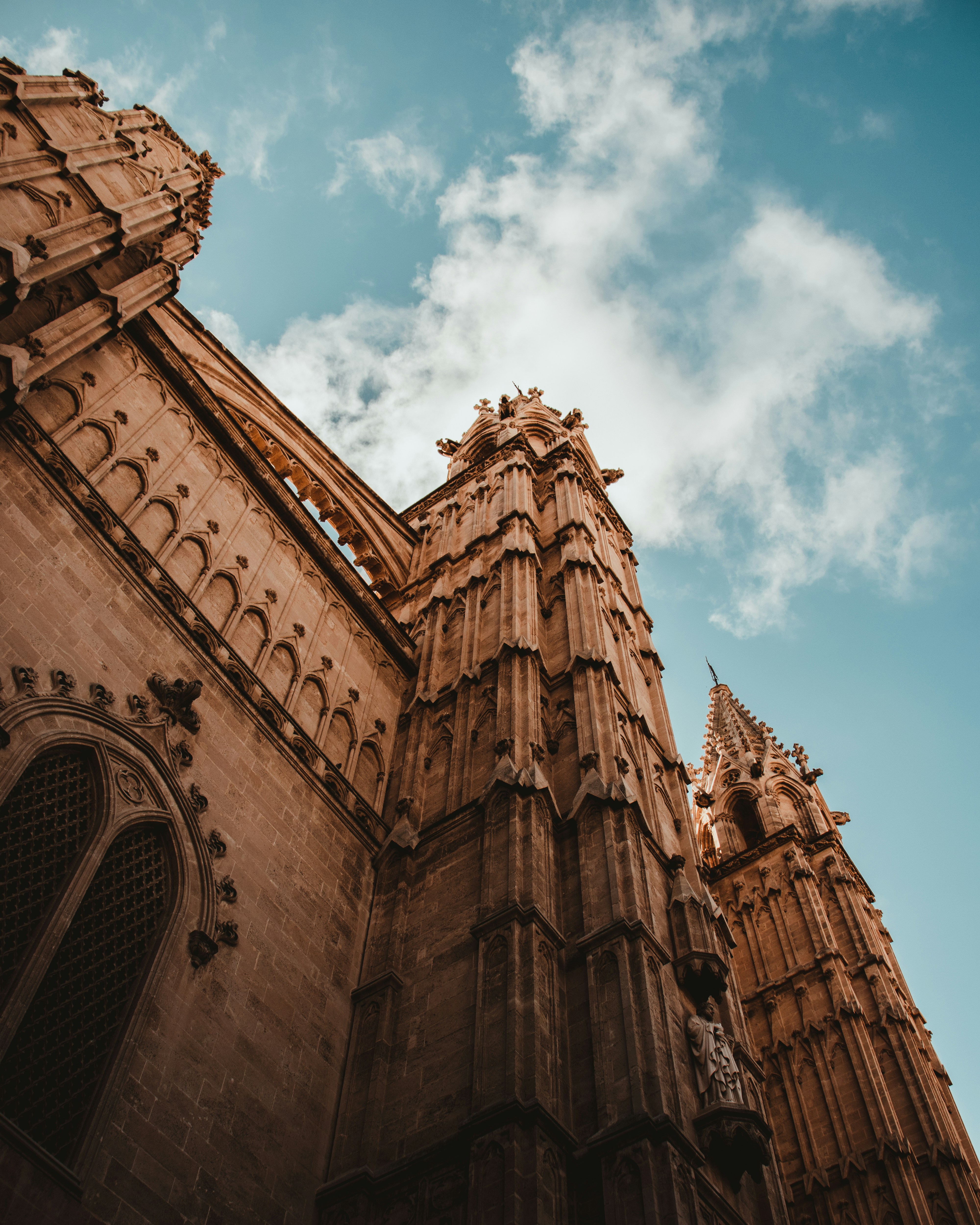 low angle photography of brown concrete building under blue sky during daytime