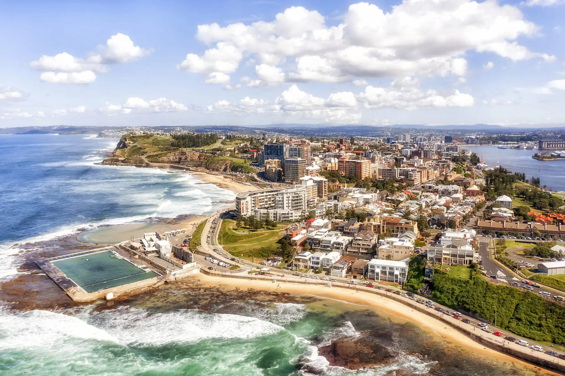 Coastal city with ocean, beach, and buildings.