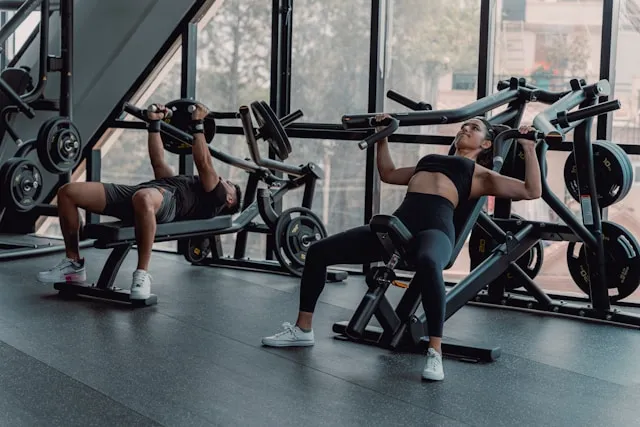Man resting with eyes closed in a dimly lit gym after physical effort