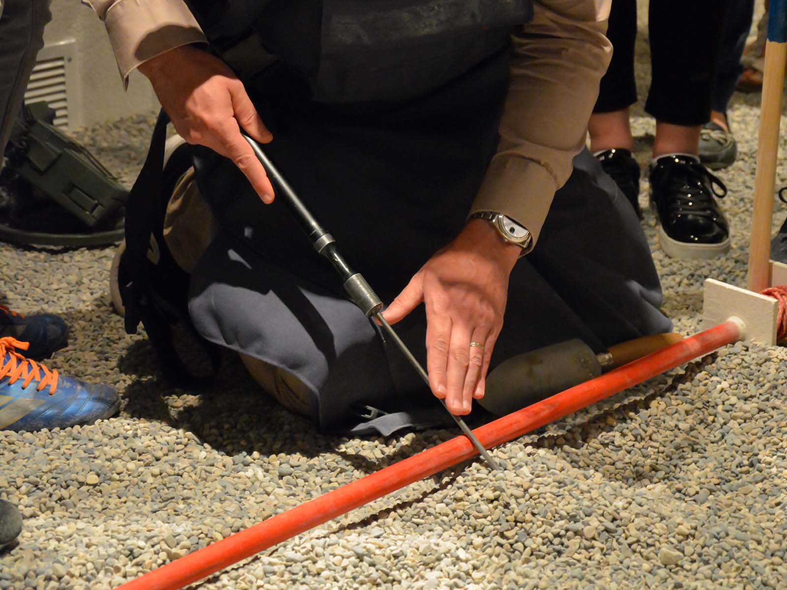 Un visiteur effectue le déminage manuel du terrain pendant la visite.