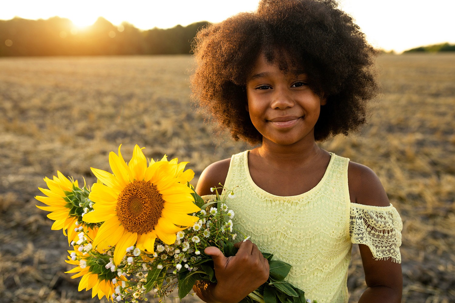 Young girl holding sunflowers at dusk