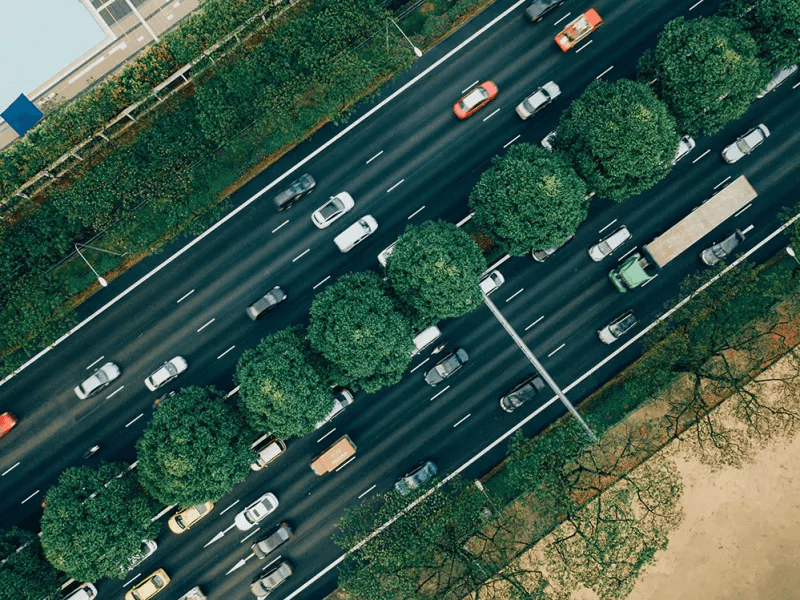 Aerial image of a motorway, with plenty of trees and vegetation in the central reservation and surrounding areas.