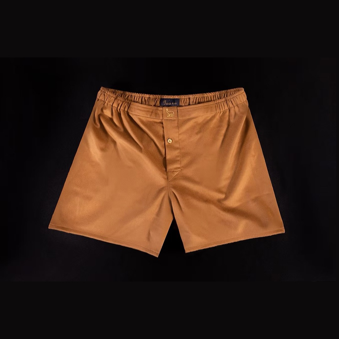 Modern home office setup with a monitor, ergonomic chair, keyboard, and indoor plants near a window with blinds.