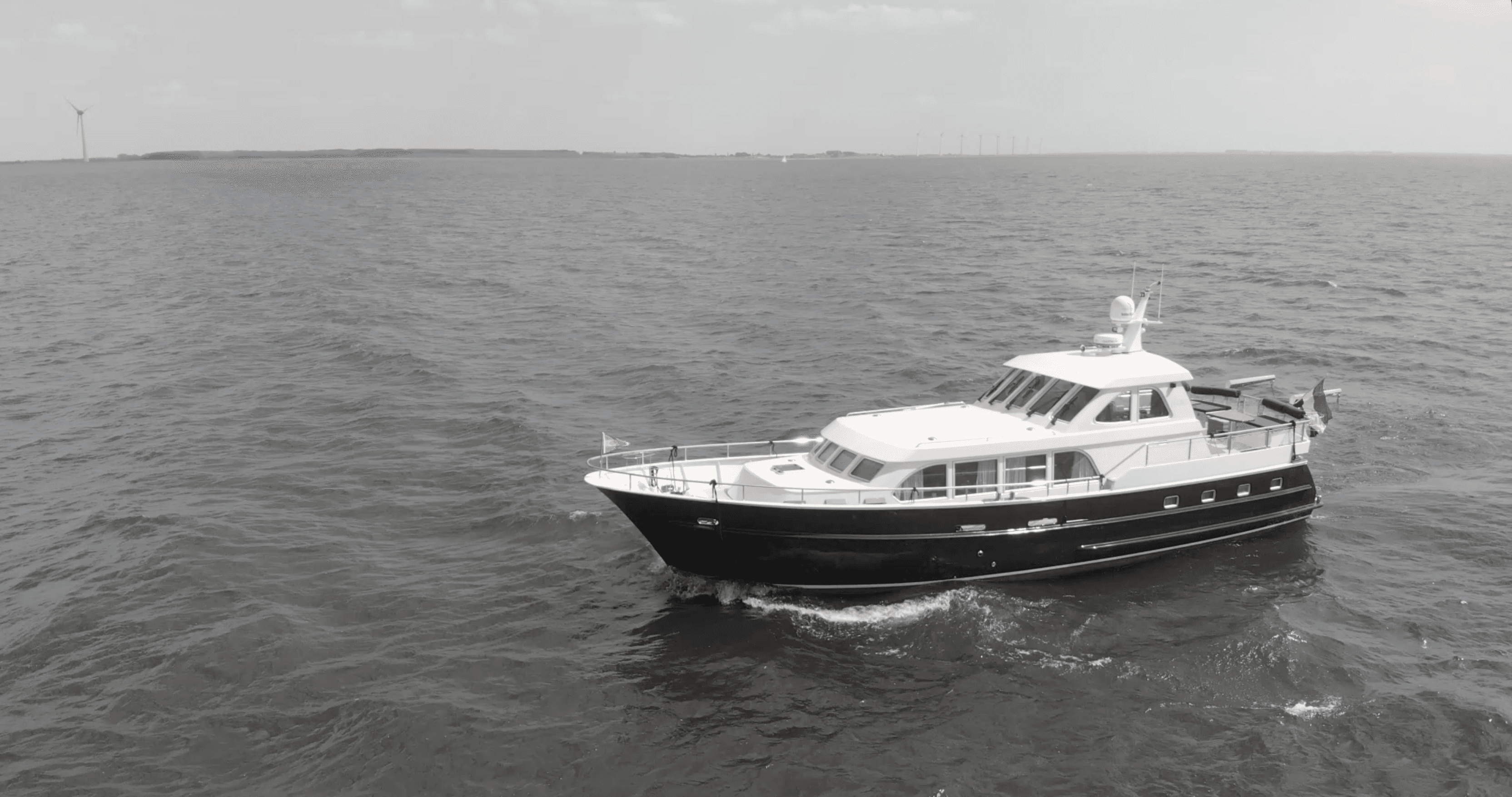 nfinity pool blending into the ocean view, minimalist sun loungers in soft neutral fabric, curved architecture