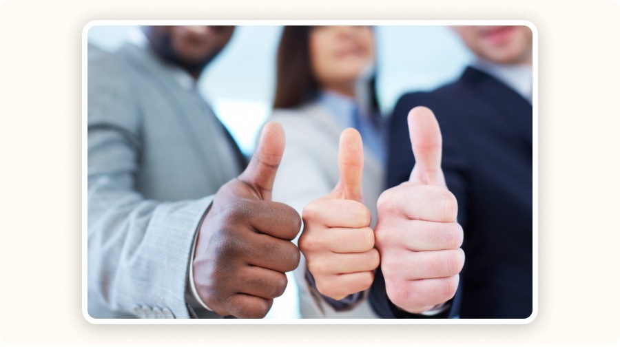 Three professionals giving thumbs up, representing approval and satisfaction