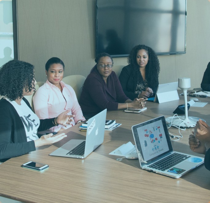 A small, diverse group of professionals gathered around a meeting table, symbolizing collaborative and inclusive approaches to compensation consulting