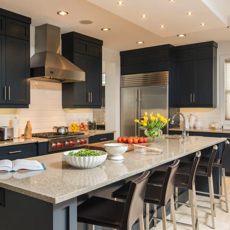 Image of Modern kitchen design with island, stainless steel appliances, and dark cabinets by KHD Homes.