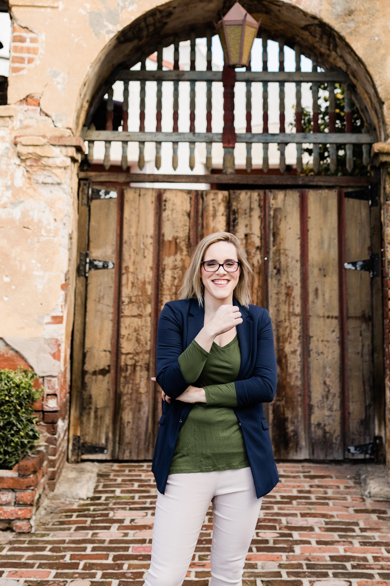 Kristin Martinez, LMFT, standing by warm wooden doors outdoors