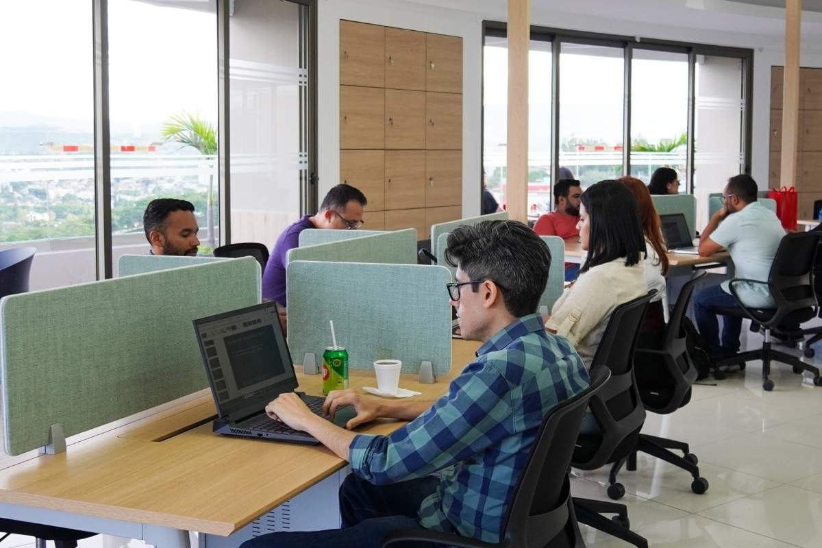 People working on computers at desks in an office.