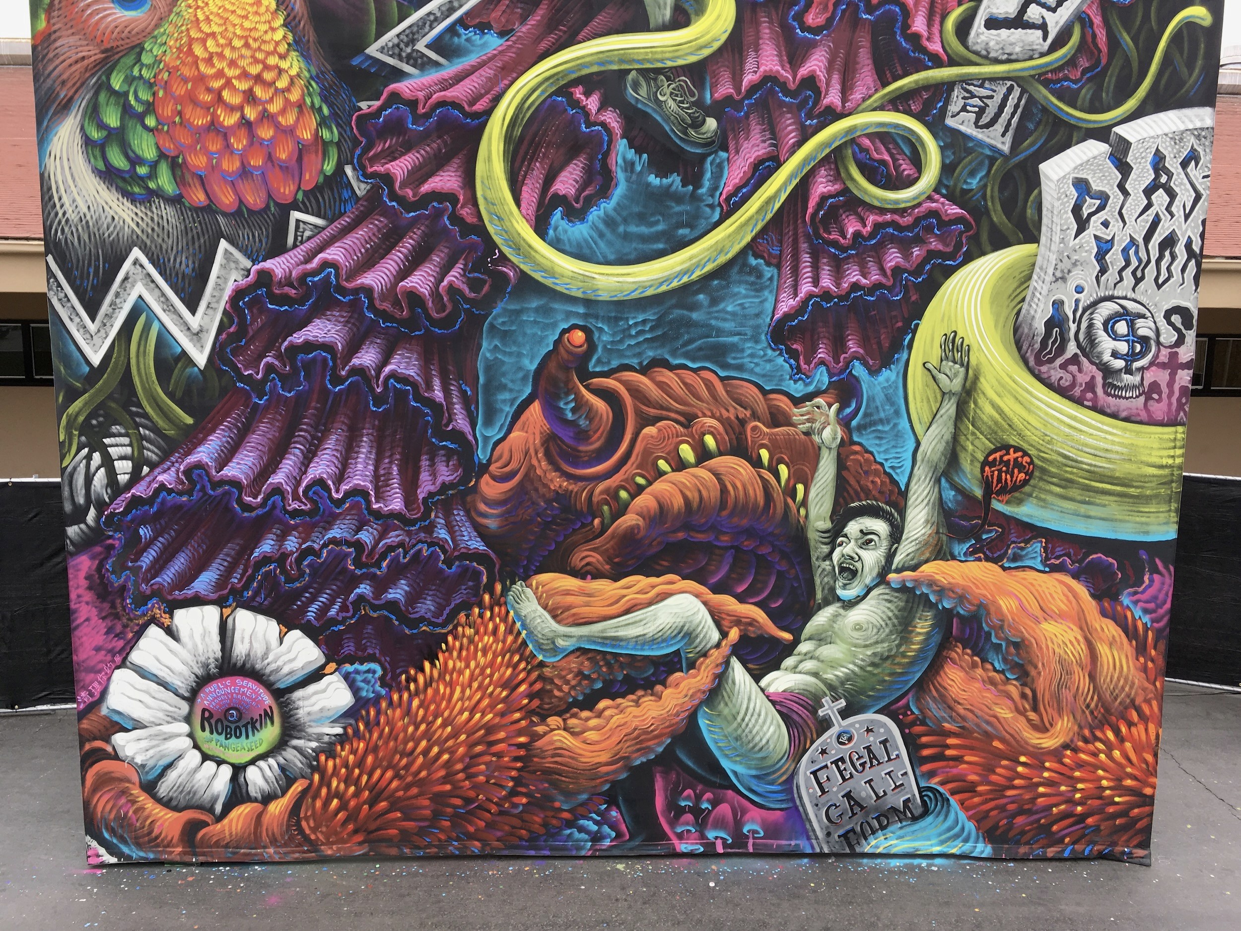 A purple and orange tangle of sea forms, a white flower and tumbling figures.