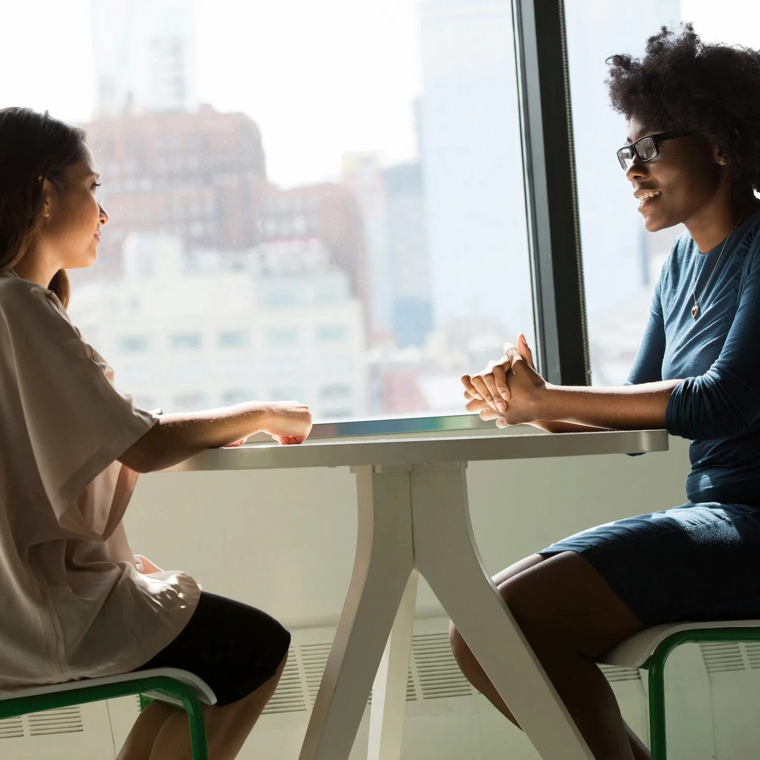 Therapist and client sitting at a table in a bright Los Angeles office during an LGBTQ couples counseling session focused on communication and understanding.