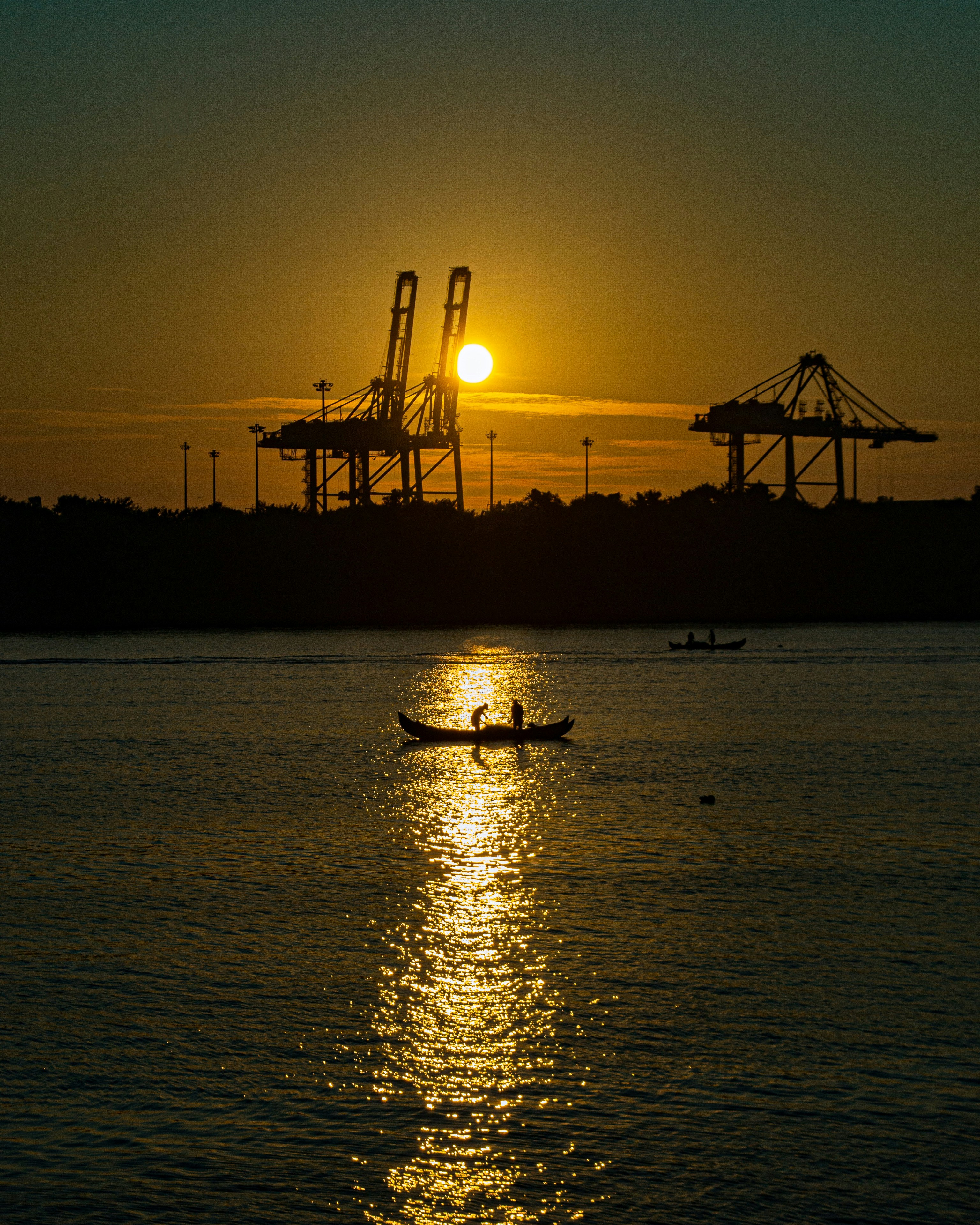 silhouette of boat on sea during sunset