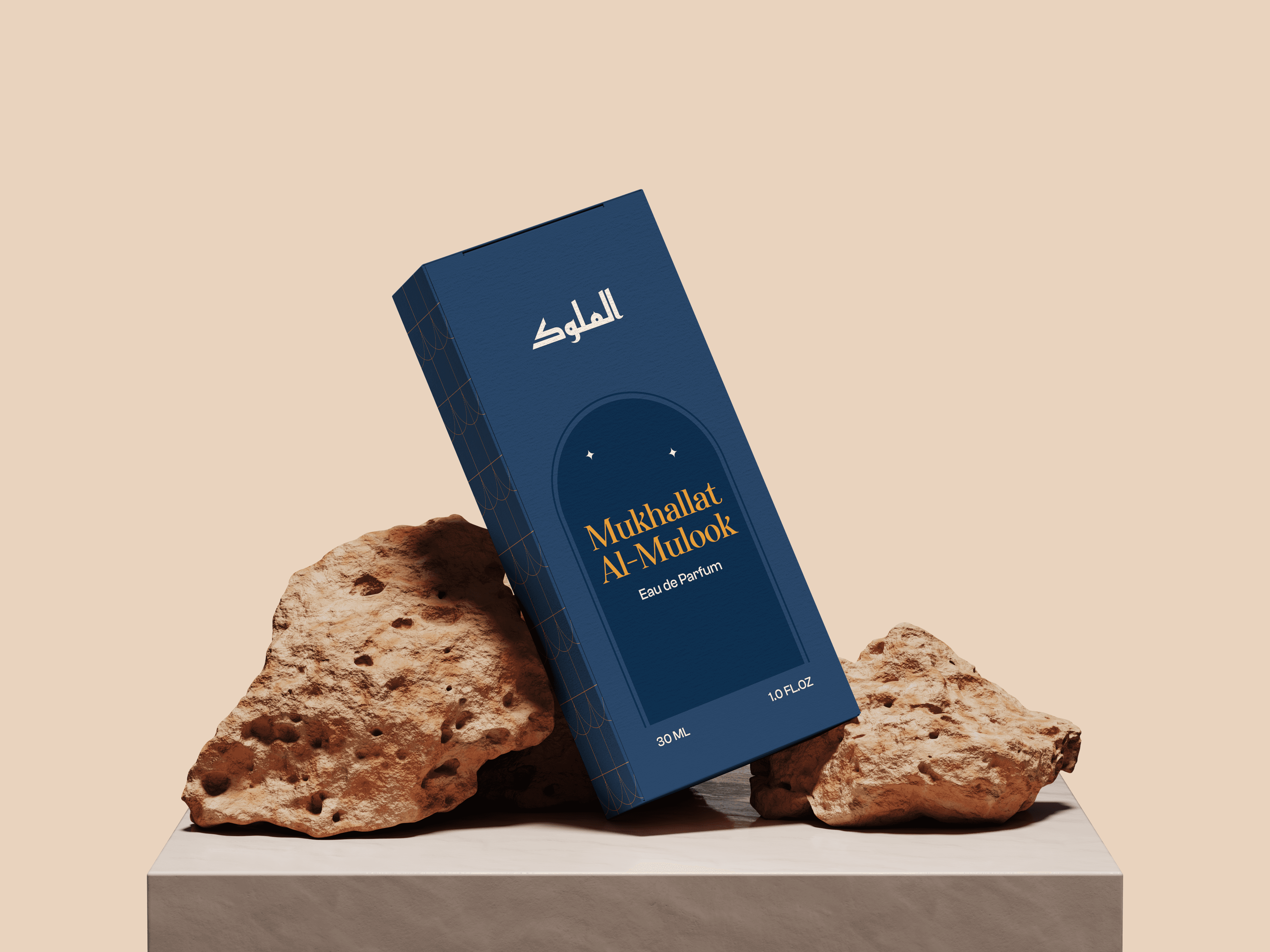 Mukhallat Al-Mulook deep blue perfume box with gold detailing styled on textured natural stones against a warm beige backdrop.