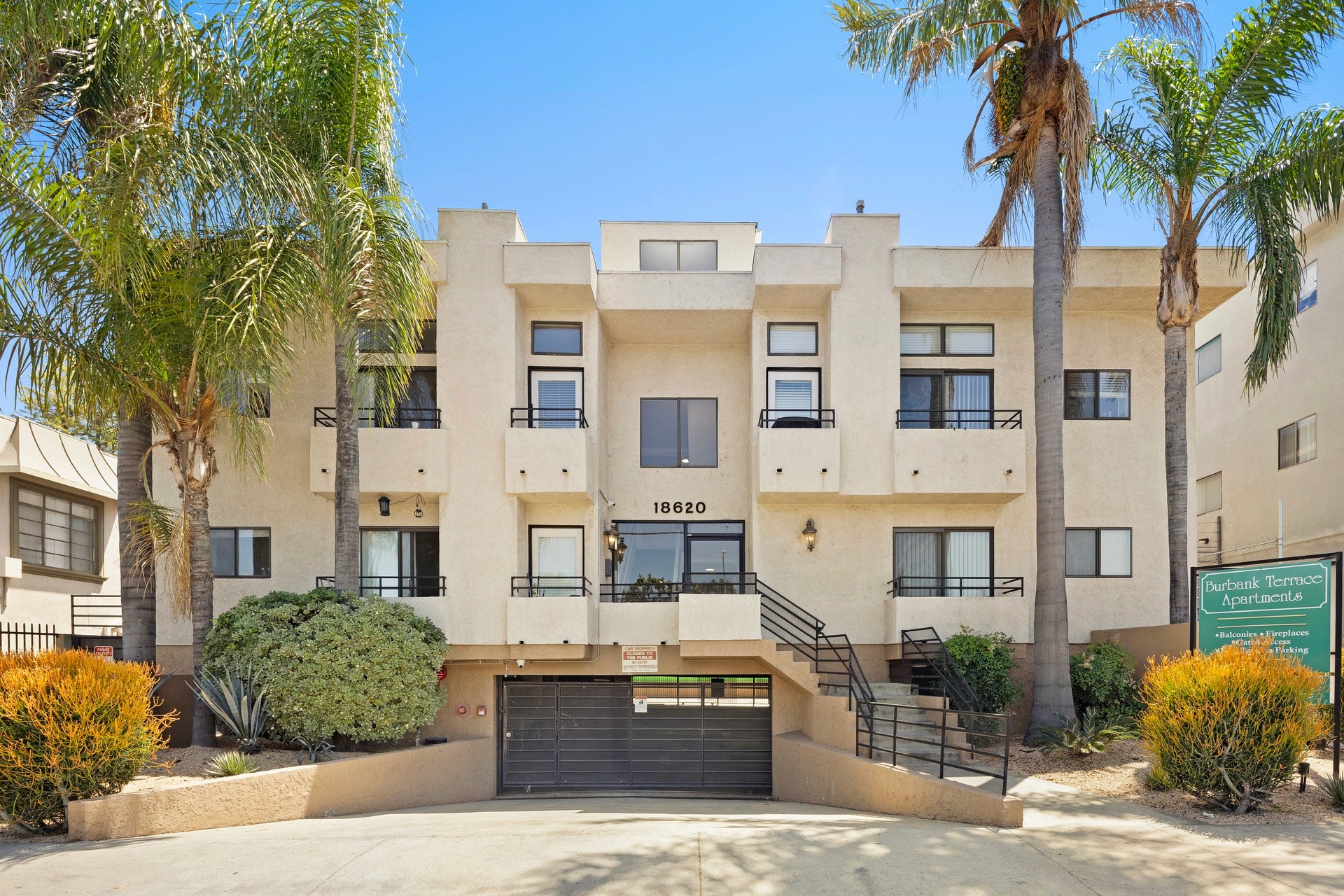 Front exterior view of 18620 burbank blvd apartment building with gated entry.