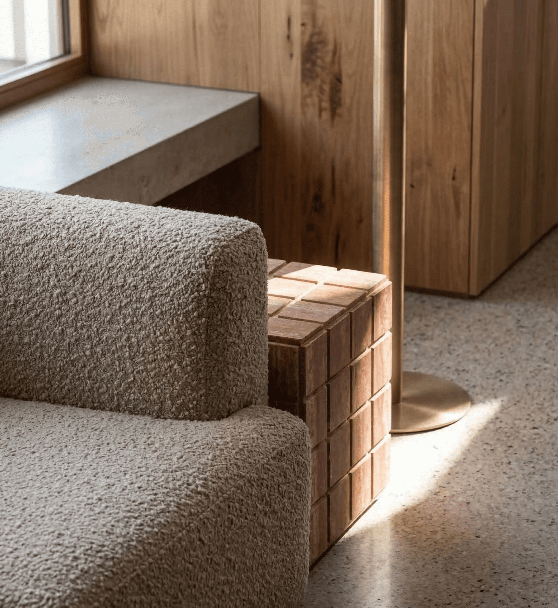 Soft peach-toned interior with curved steps, warm lighting, pampas grass, and an orange pouf.