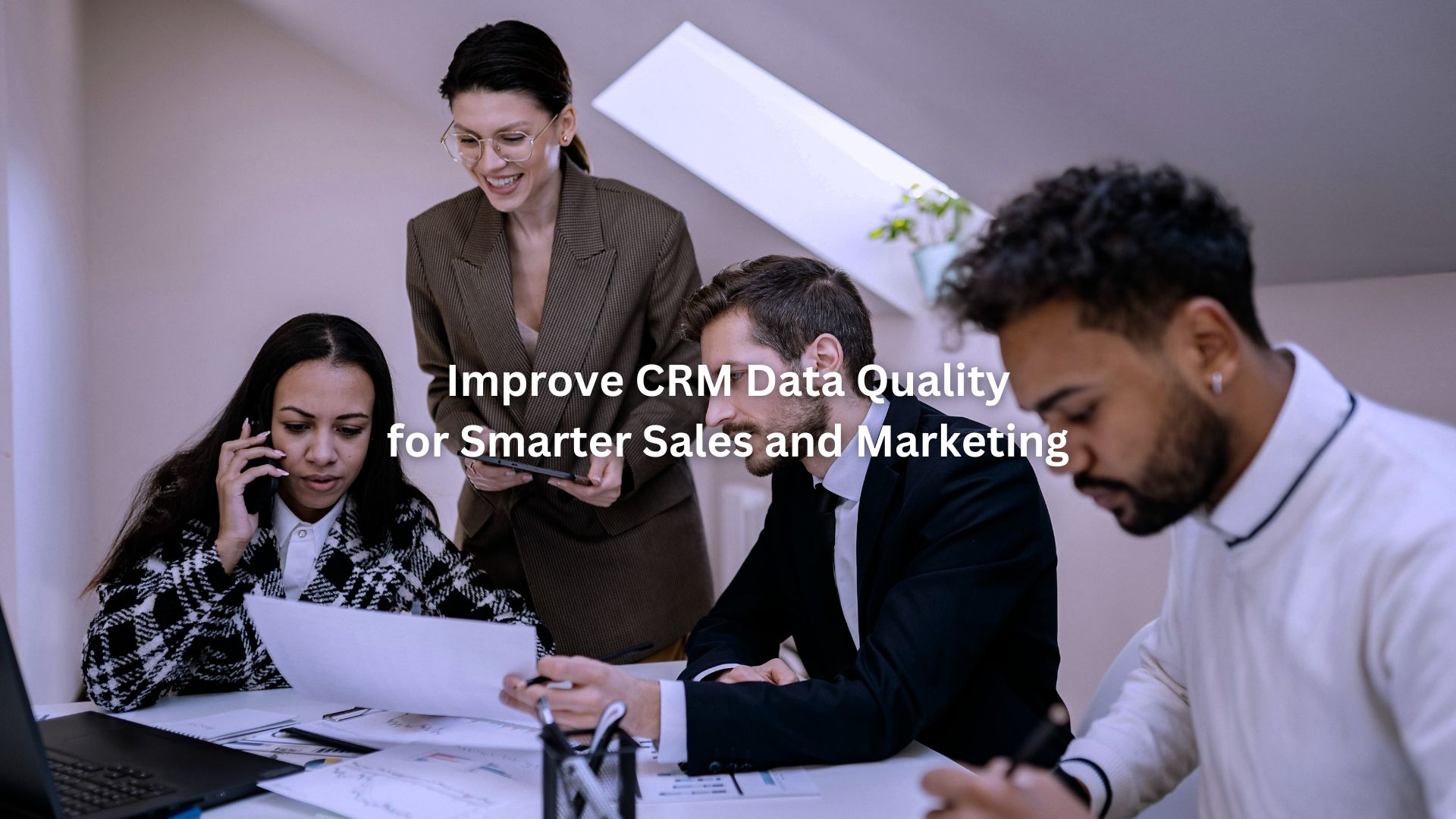 Team reviewing reports and laptop together to improve crm data quality during a collaborative office meeting.