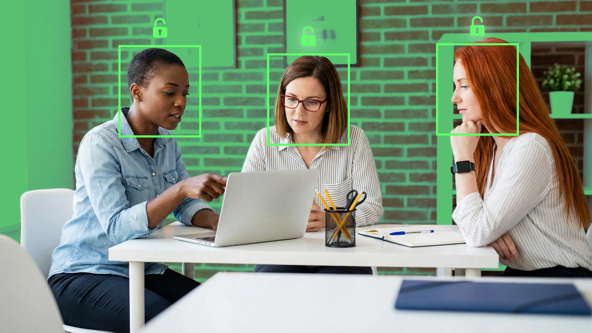 Three office professionals collaborating around a laptop in a modern workspace, with green digital facial recognition frames and "unlocked" padlock icons superimposed over their faces to represent the vulnerability of SMB employees to cyber attacks.