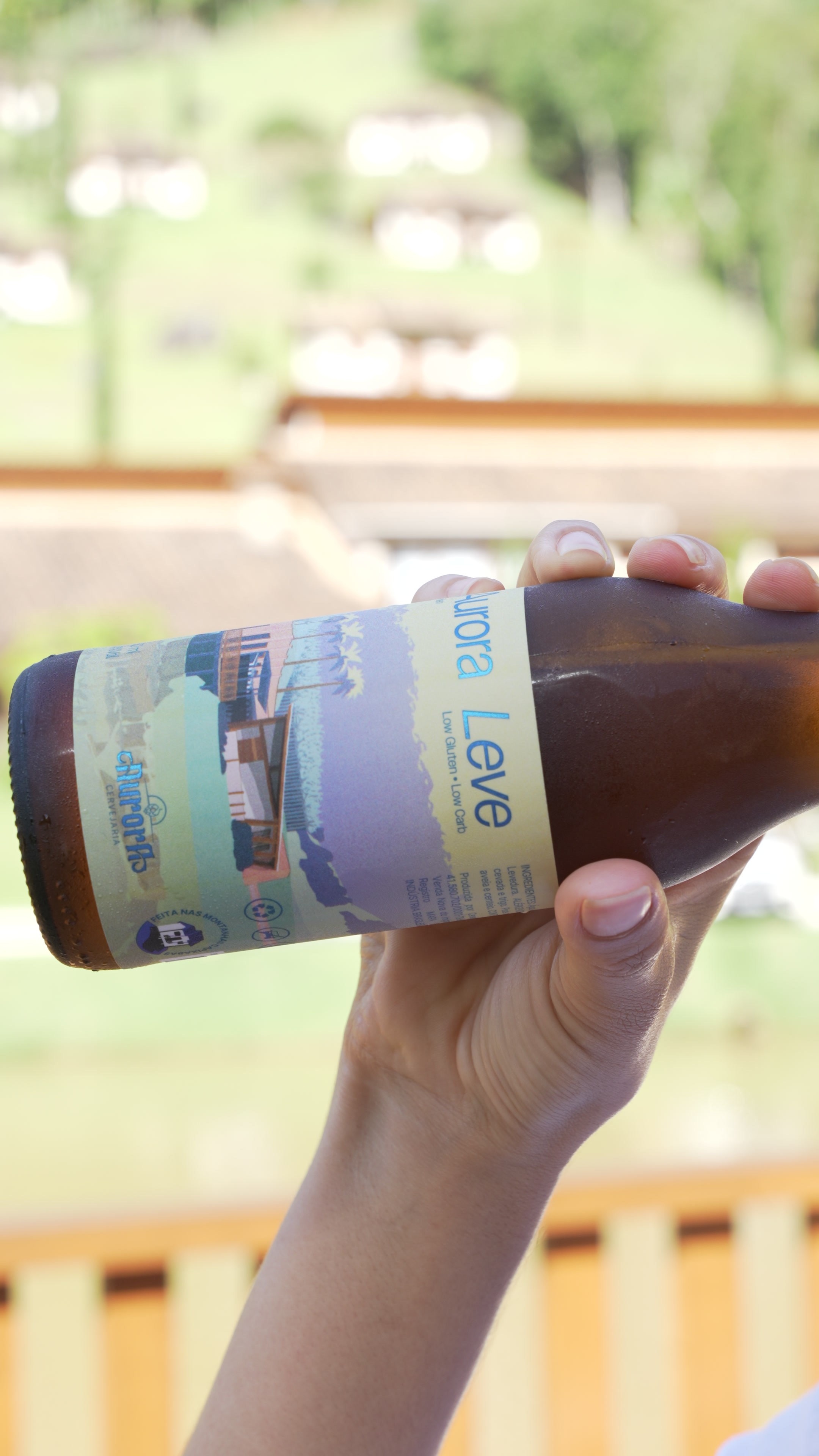 Garrafa rotulada da cerveja Aurora Leve, envasada manualmente na Cervejaria Aurora