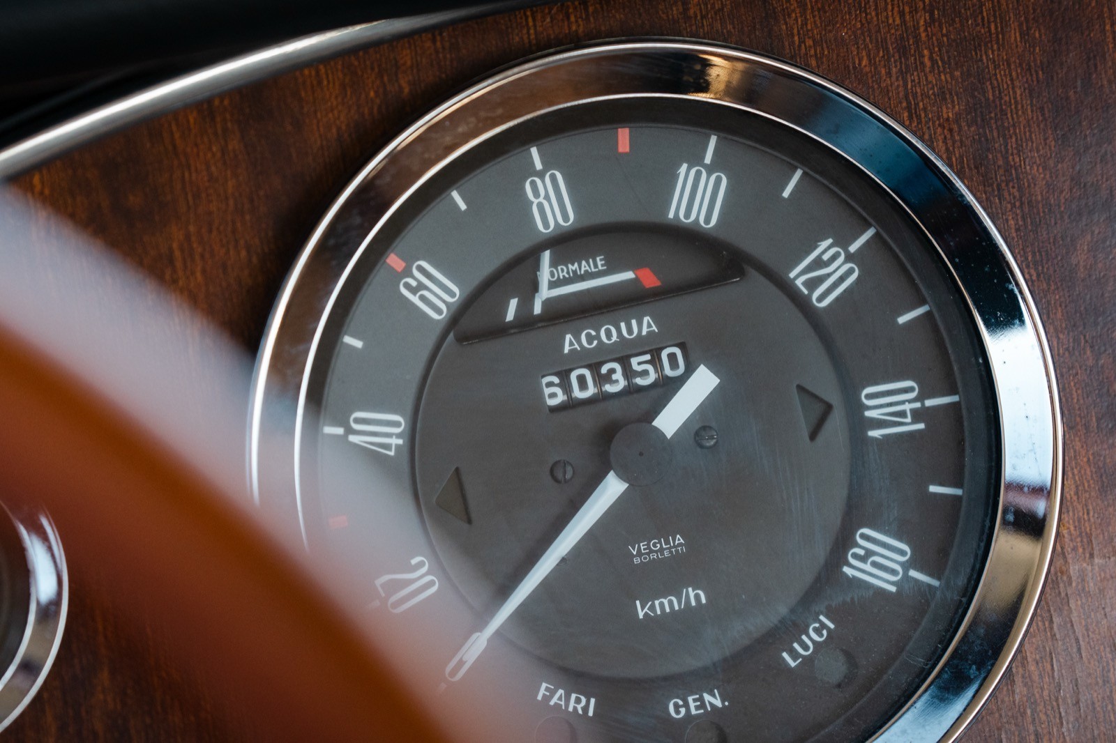 Close-up of a car's speedometer, showing the needle pointing to a speed reading on a dark dial.