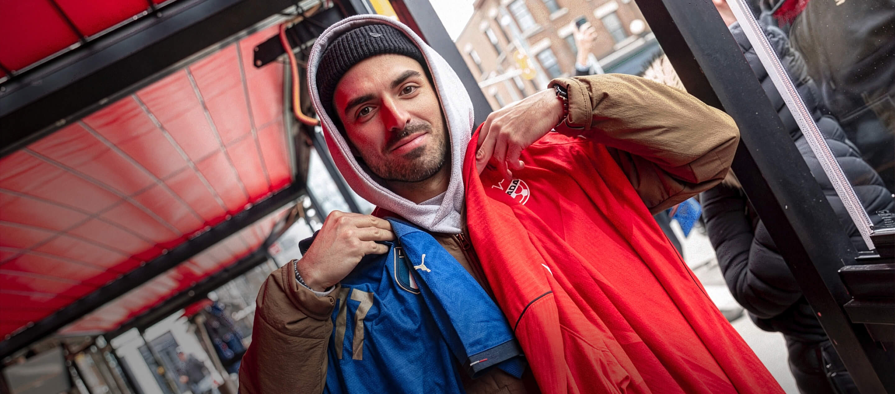 A soccer fan swaps his Italy jersey for a Canadian one.
