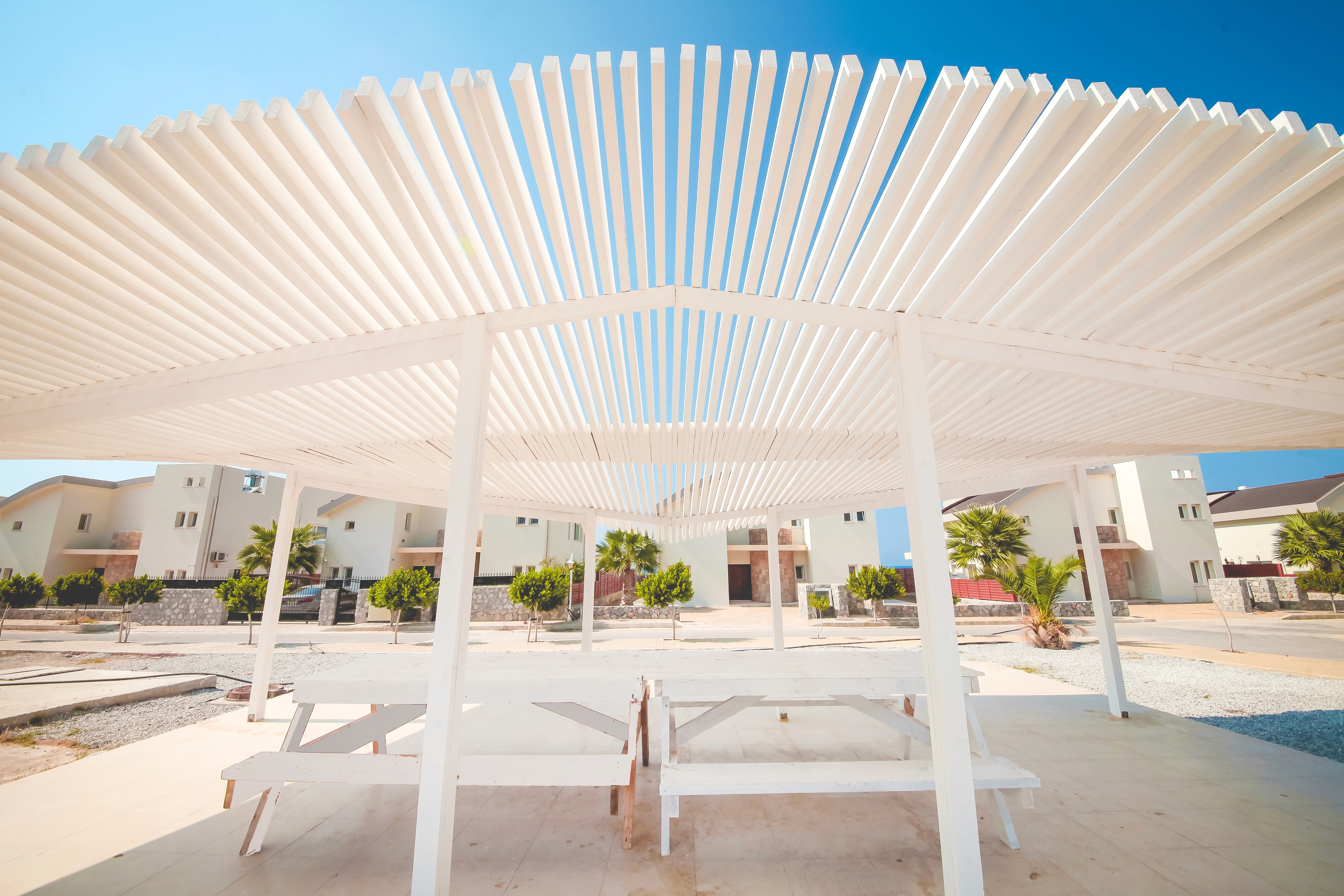 Dimly lit room with sunlight filtering through curtains, casting shadows on a green marble table with a single plate of pasta in the center.