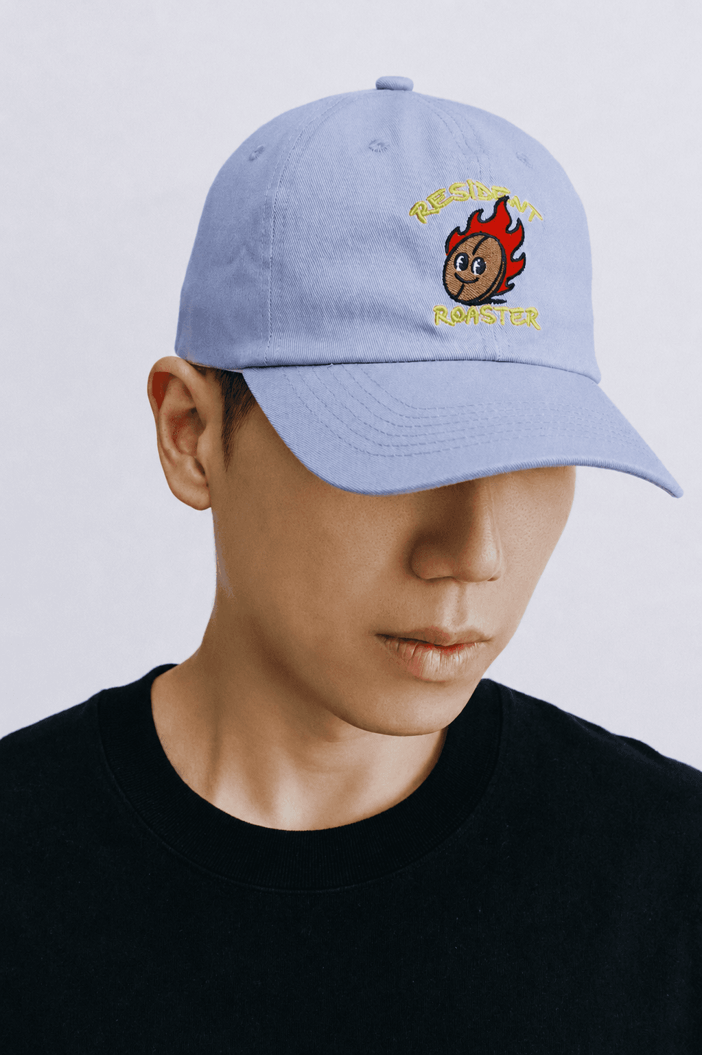 Man wearing a light blue Palpitation Roasters cap with the flame mascot