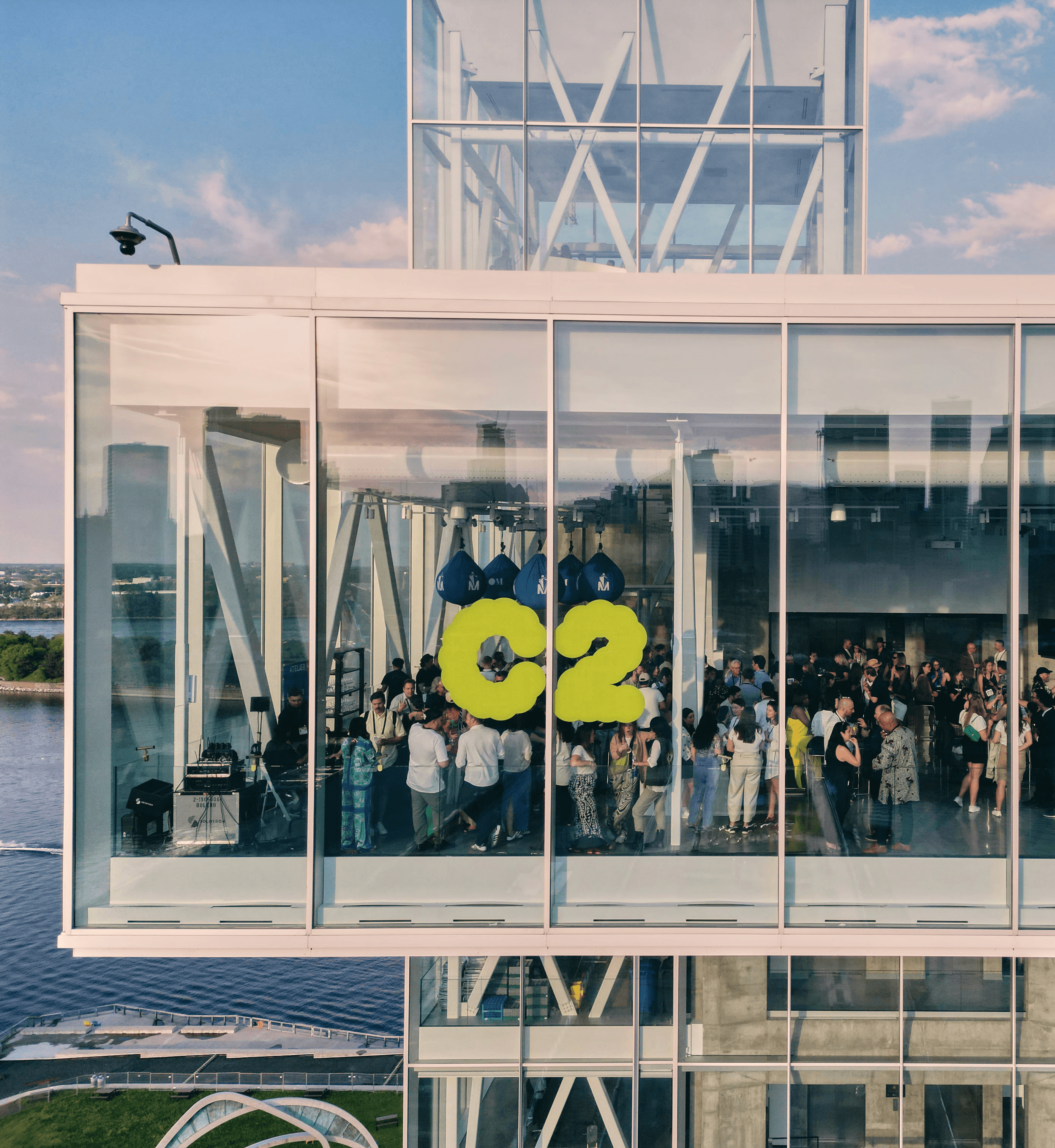 Attendees gathered behind glass windows featuring the C2 logo during a major conference moment.