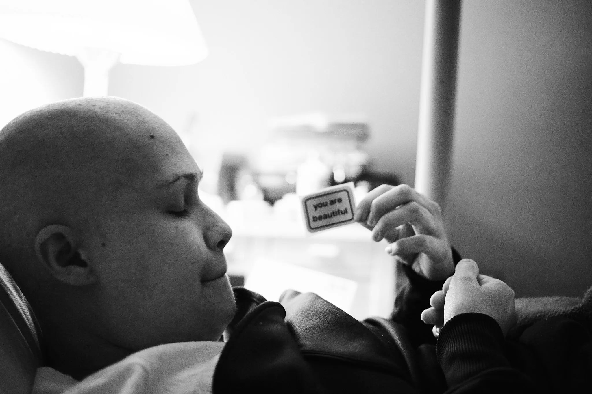 bald patient holding you are beautiful card — portrait photography by Tom Kubik
