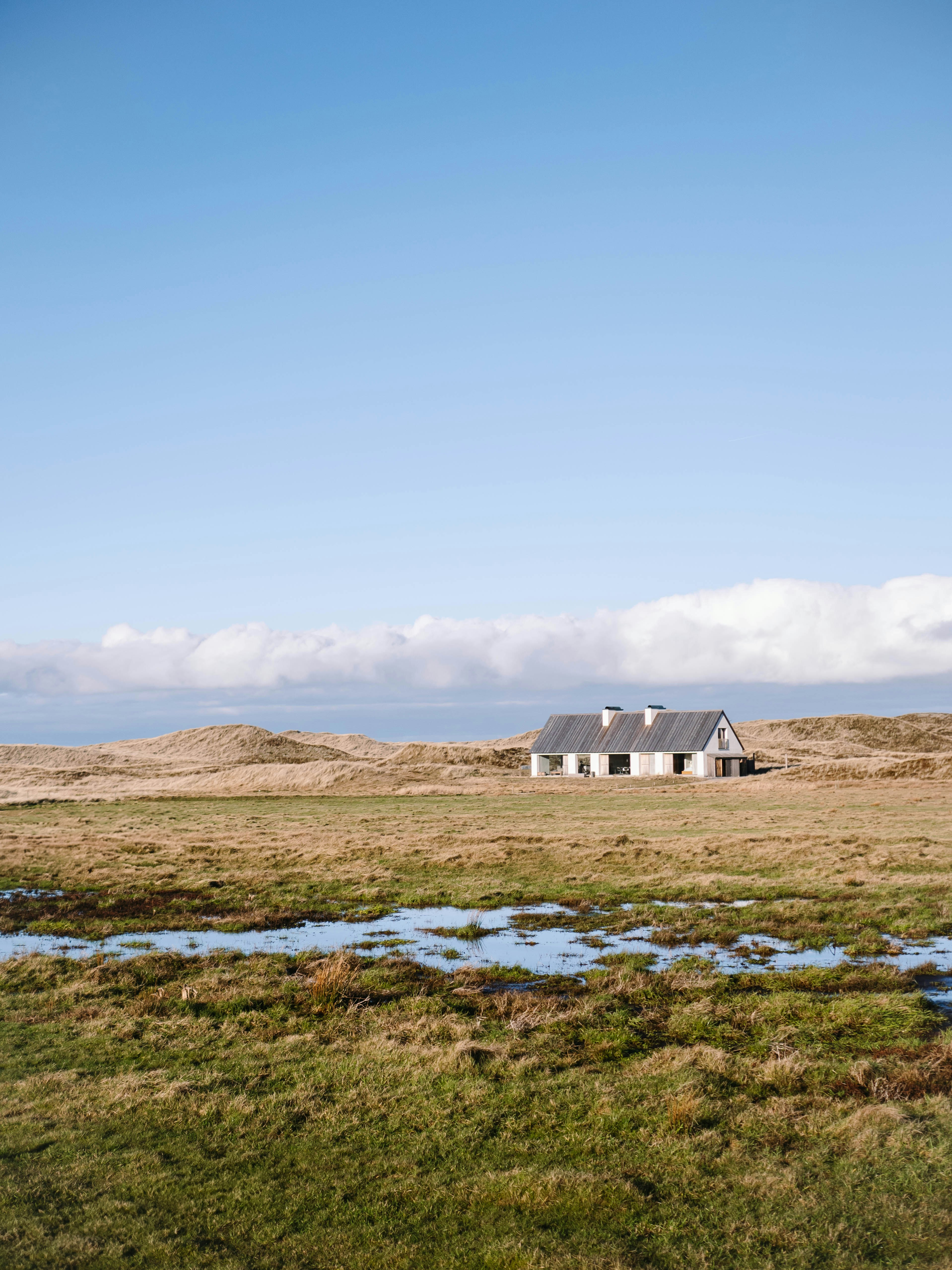 A house in a field with a stream running through it