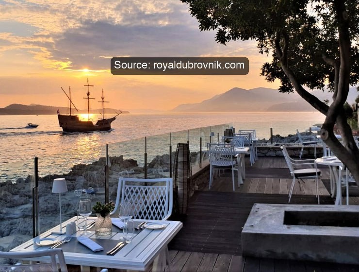 Sunset terrace at Royal Dubrovnik with a sailing ship offshore