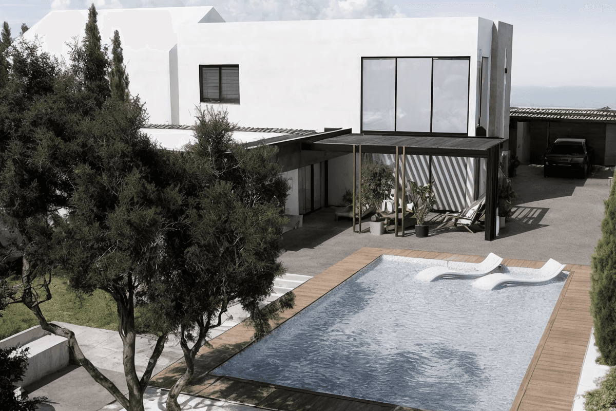 Modern timber-clad residence with horizontal wood facade and geometric volumes set on manicured lawn