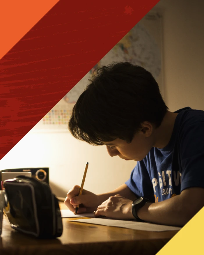 Little boy writing under dim lamp light