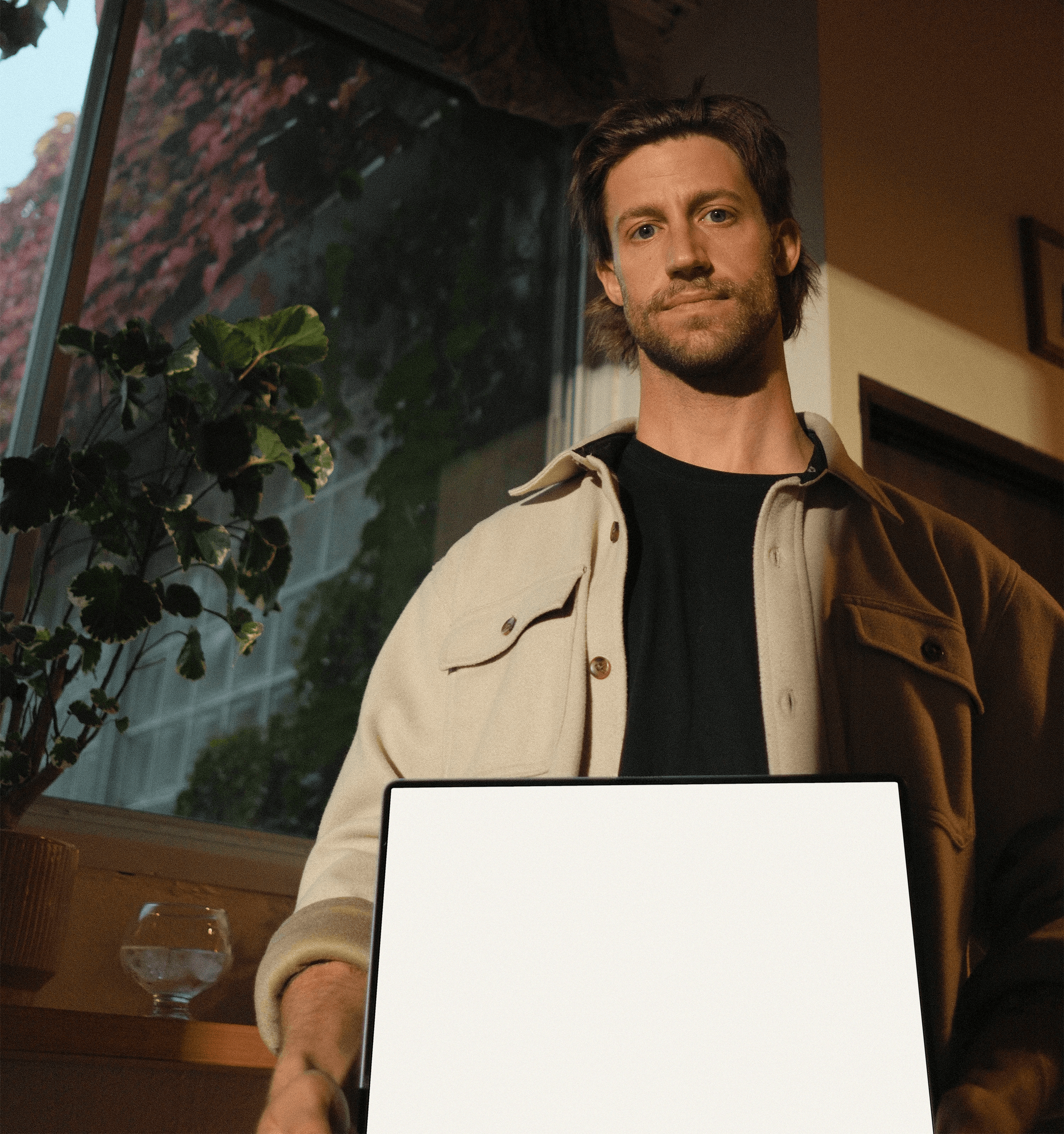 Personne tenant un écran vide dans un intérieur éclairé naturellement