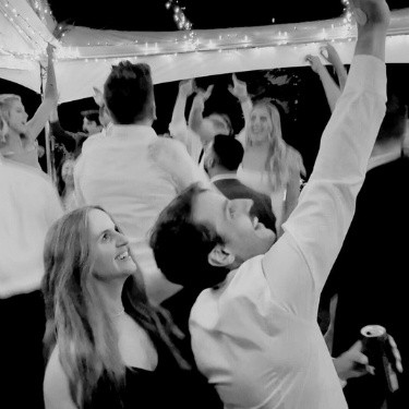 A wedding guest happily taking selfies on the dance floor, capturing fun moments while enjoying the celebration.