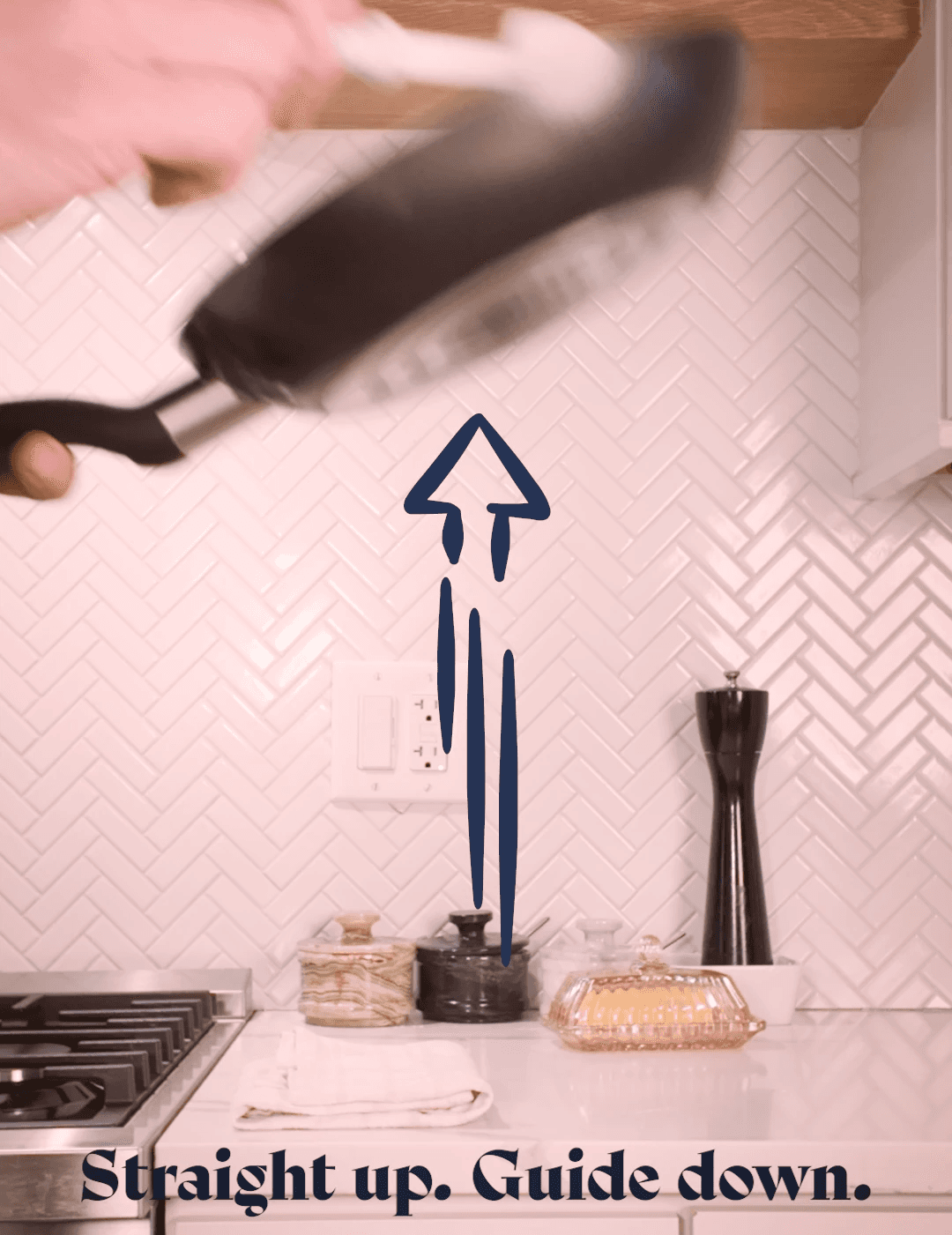 A skillet being shown in the process of flipping an egg with on screen instructions that say "straight up. guide down."