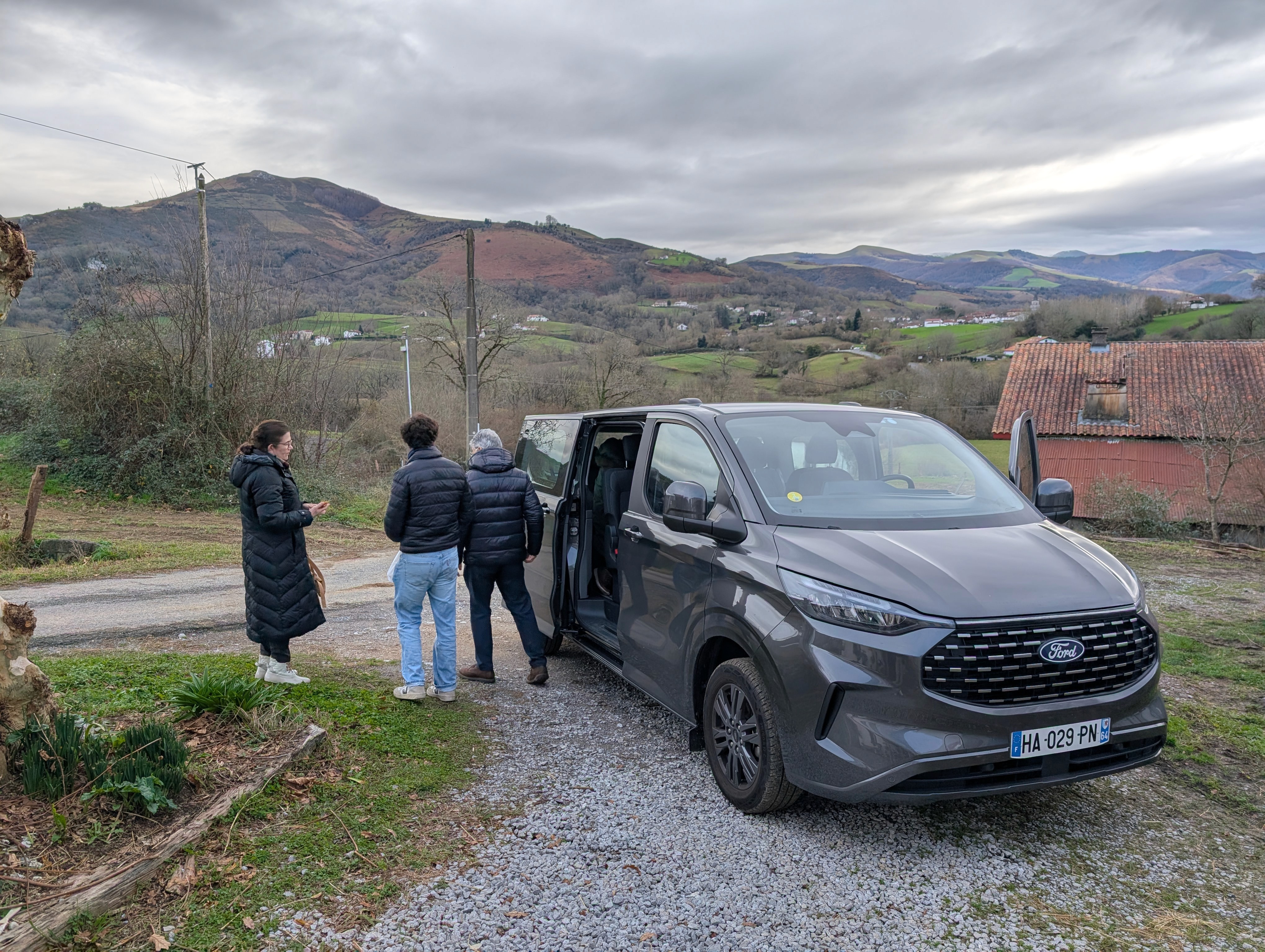 Guests boarding a premium van for a private tour in the Basque countryside, mountains in the background.