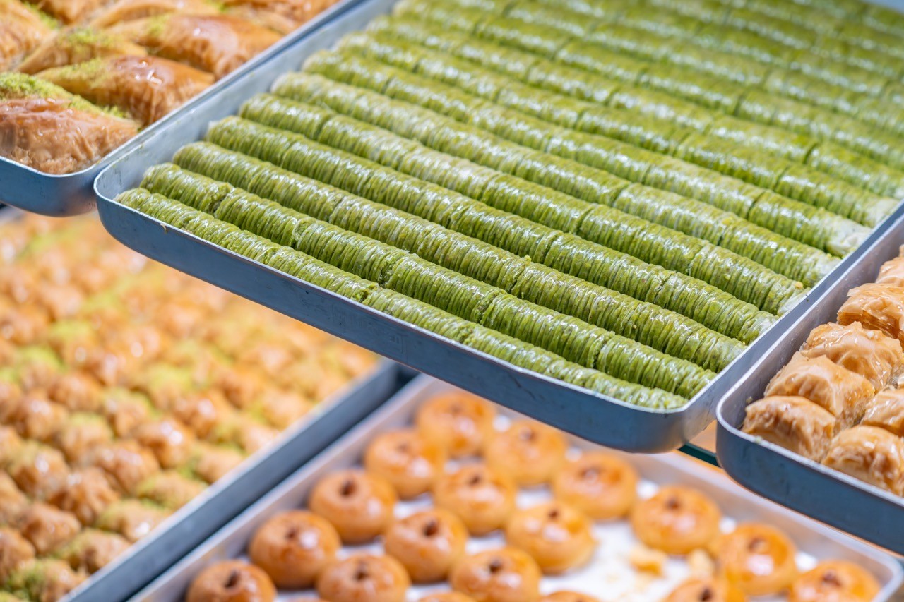 Vers bereide baklava en pistachegebak in de vitrine van Bakkerij Firat