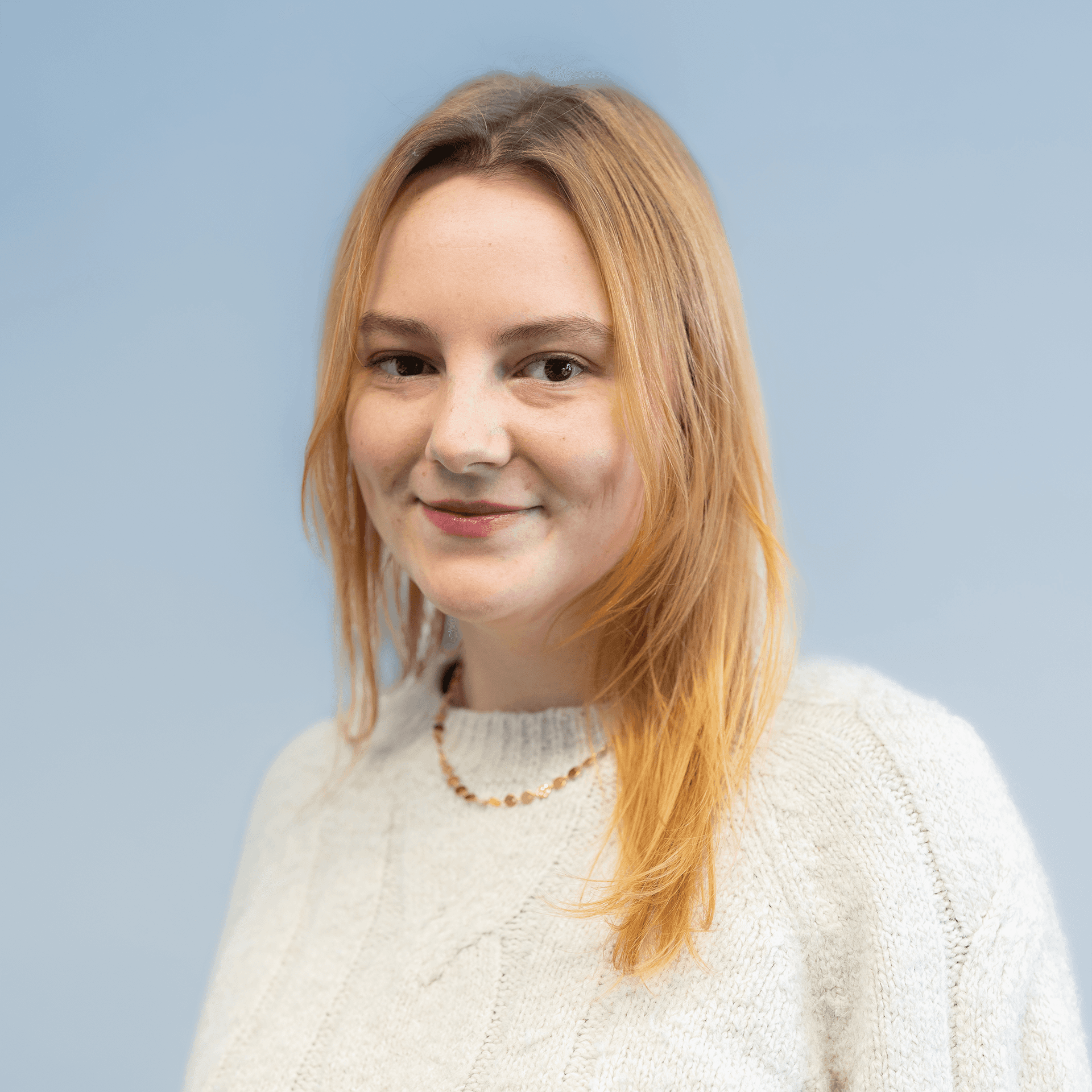 Portrait of a laughing person with curly hair wearing a white shirt