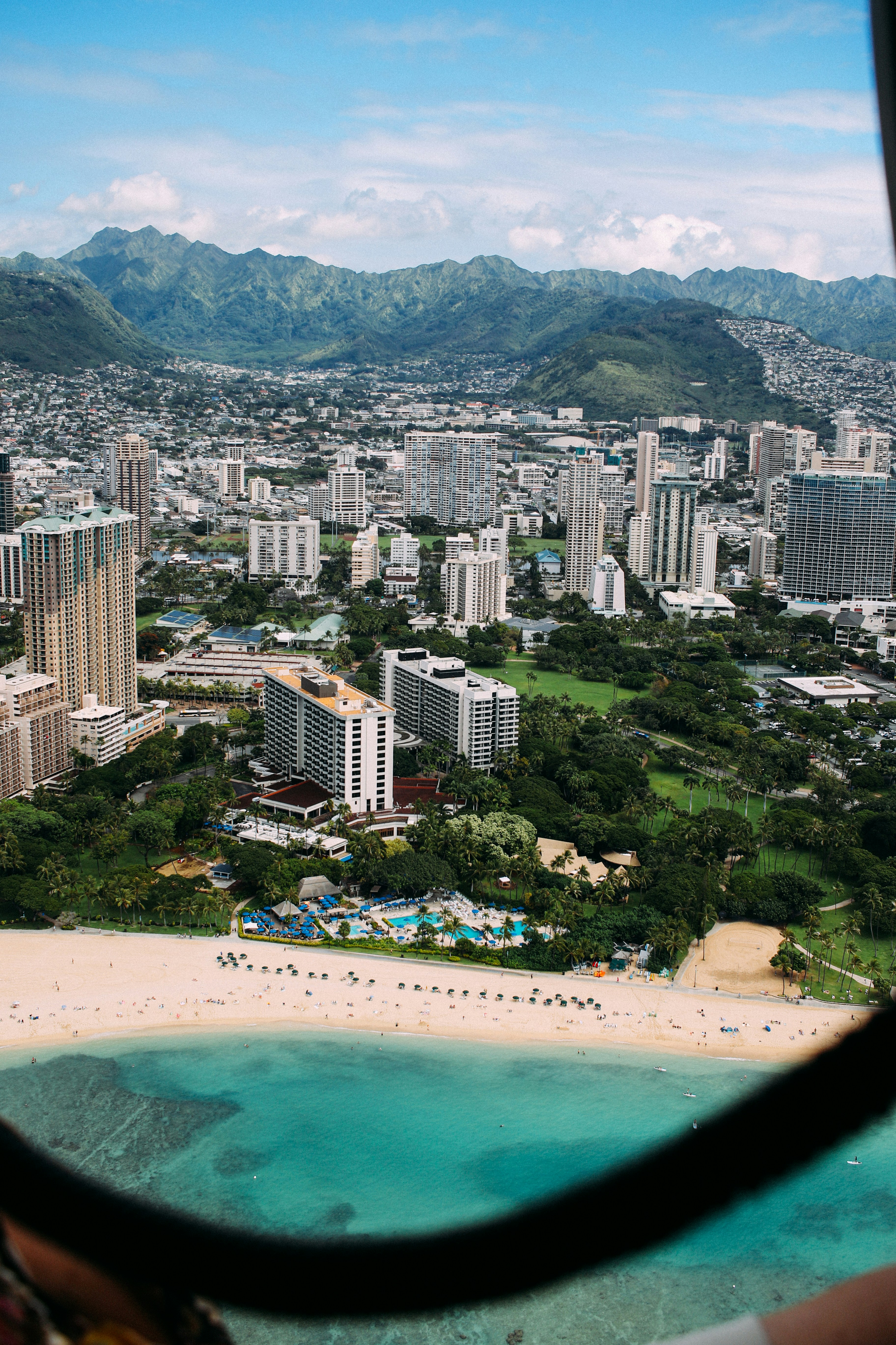 aerial photo of city high rise building and seashore under cloudy sky during daytime