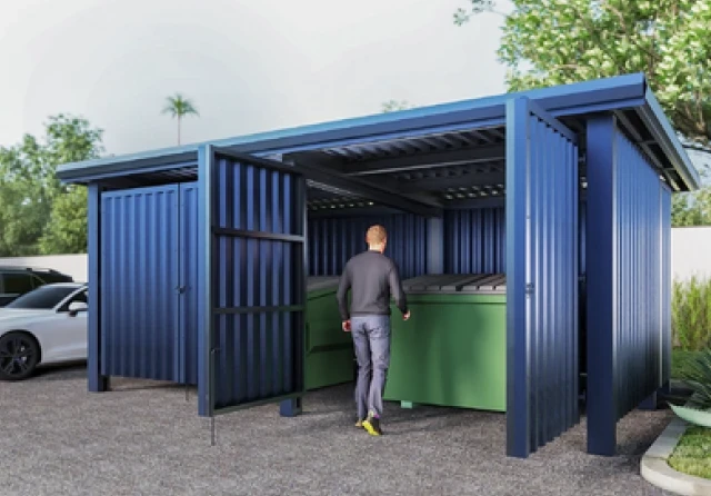 secure dumpster enclosure with person walking in