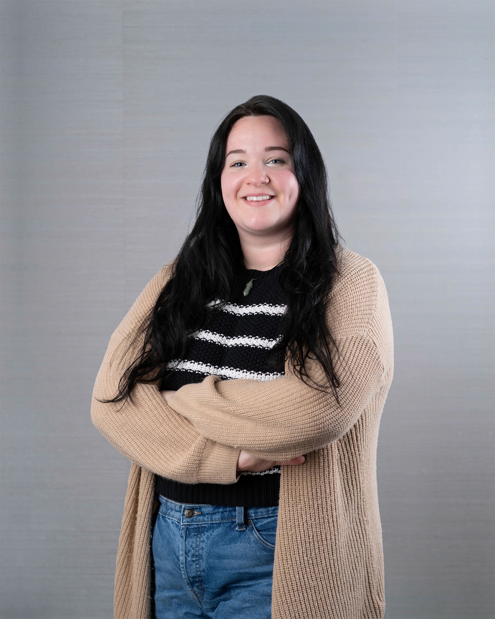Young woman with long black hair, smiling gently.
