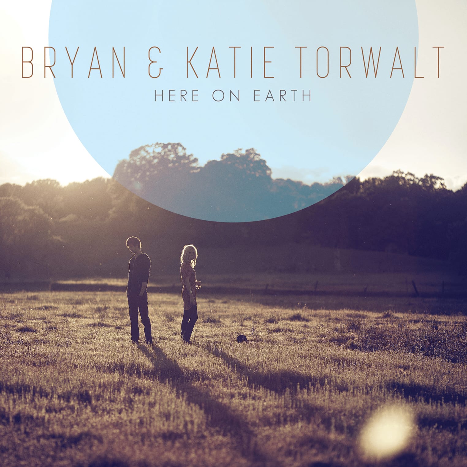 Album artwork for the worship song "Holy Spirit" by Jesus Culture: Two people stand in a sunlit field with trees. Text reads "Bryan & Katie Torwalt Here On Earth."