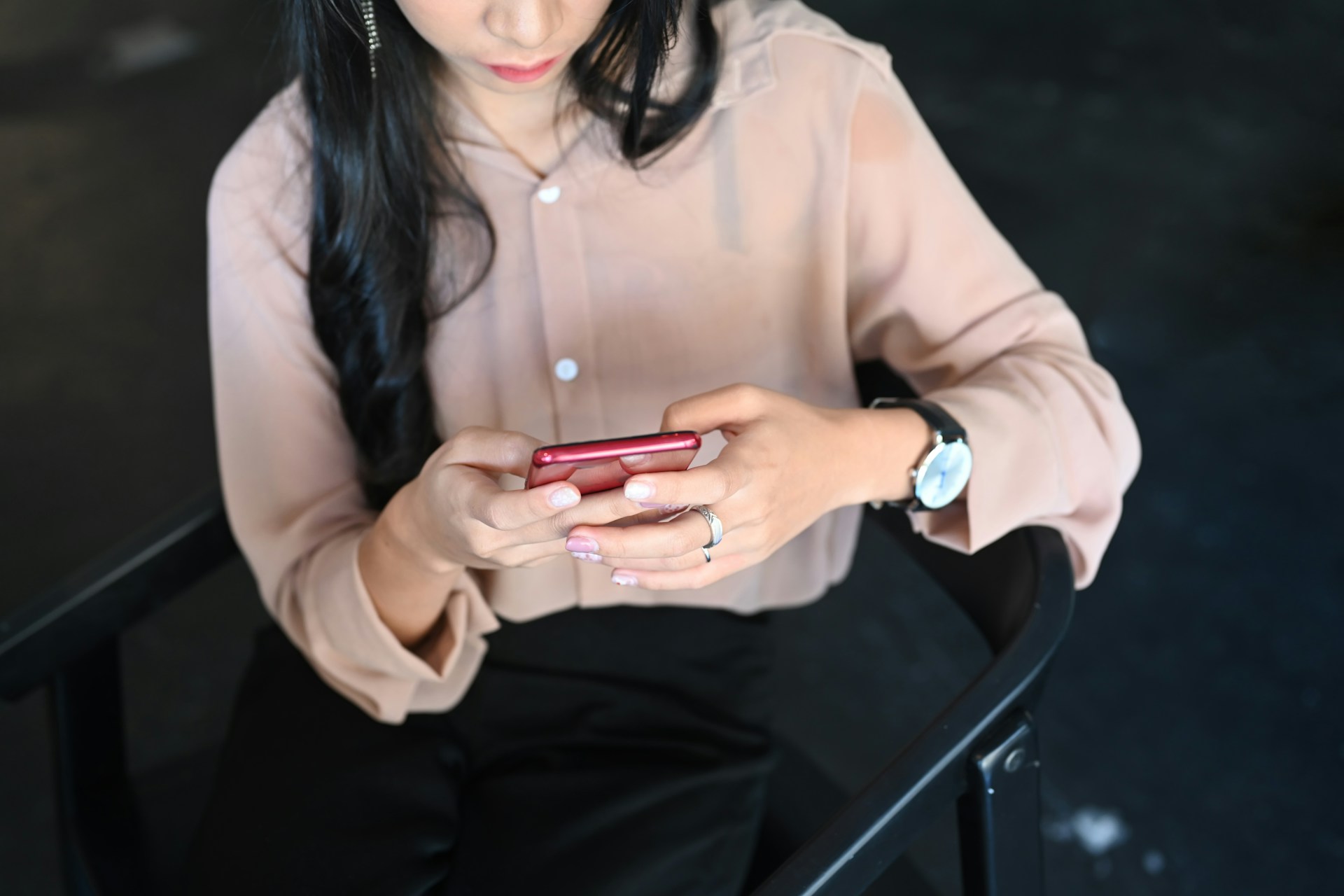 A woman sitting while using a phone