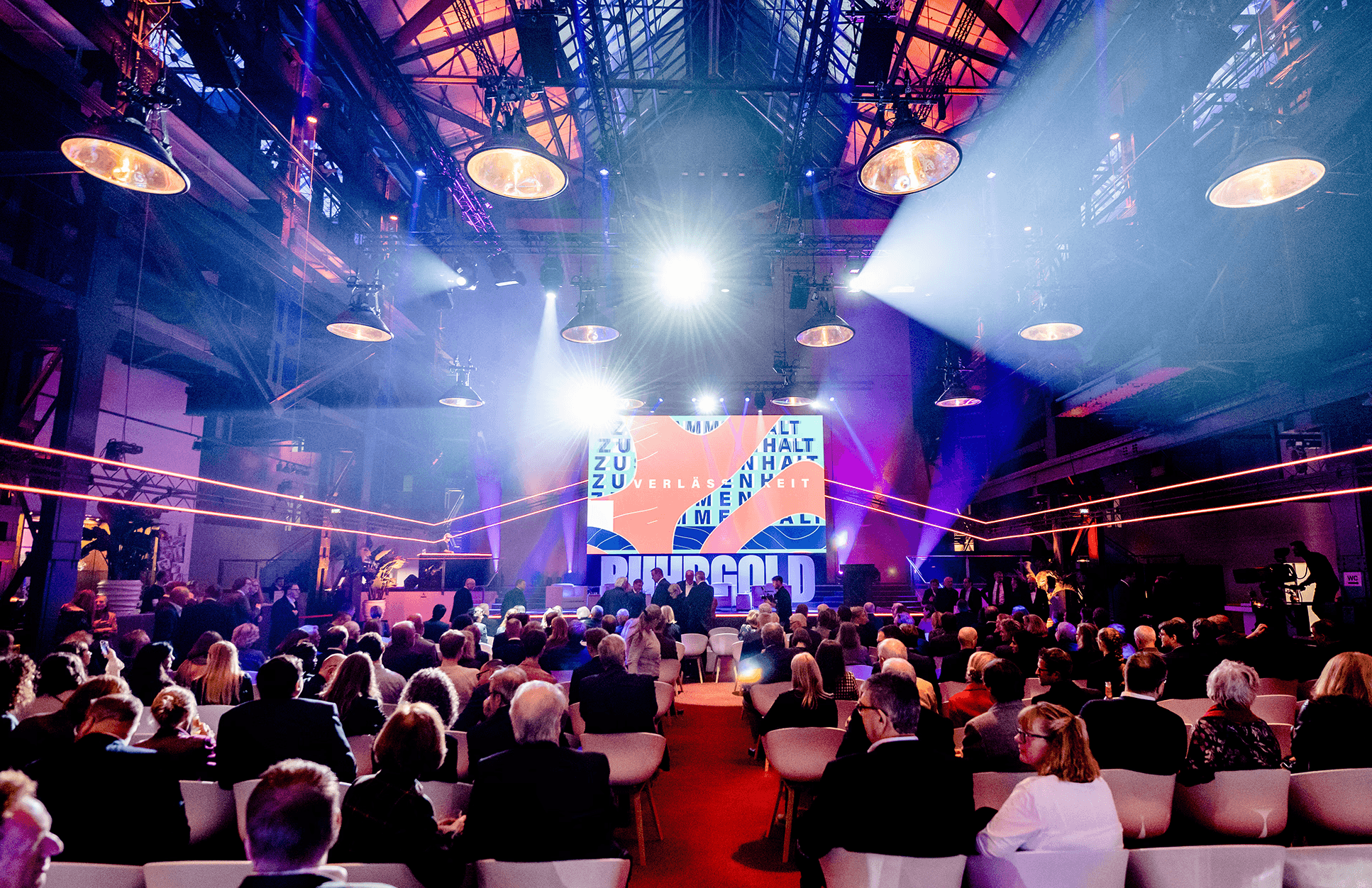 Blurred portrait of a person in an orange patterned shirt with glowing glasses, creating a futuristic and artistic vibe.