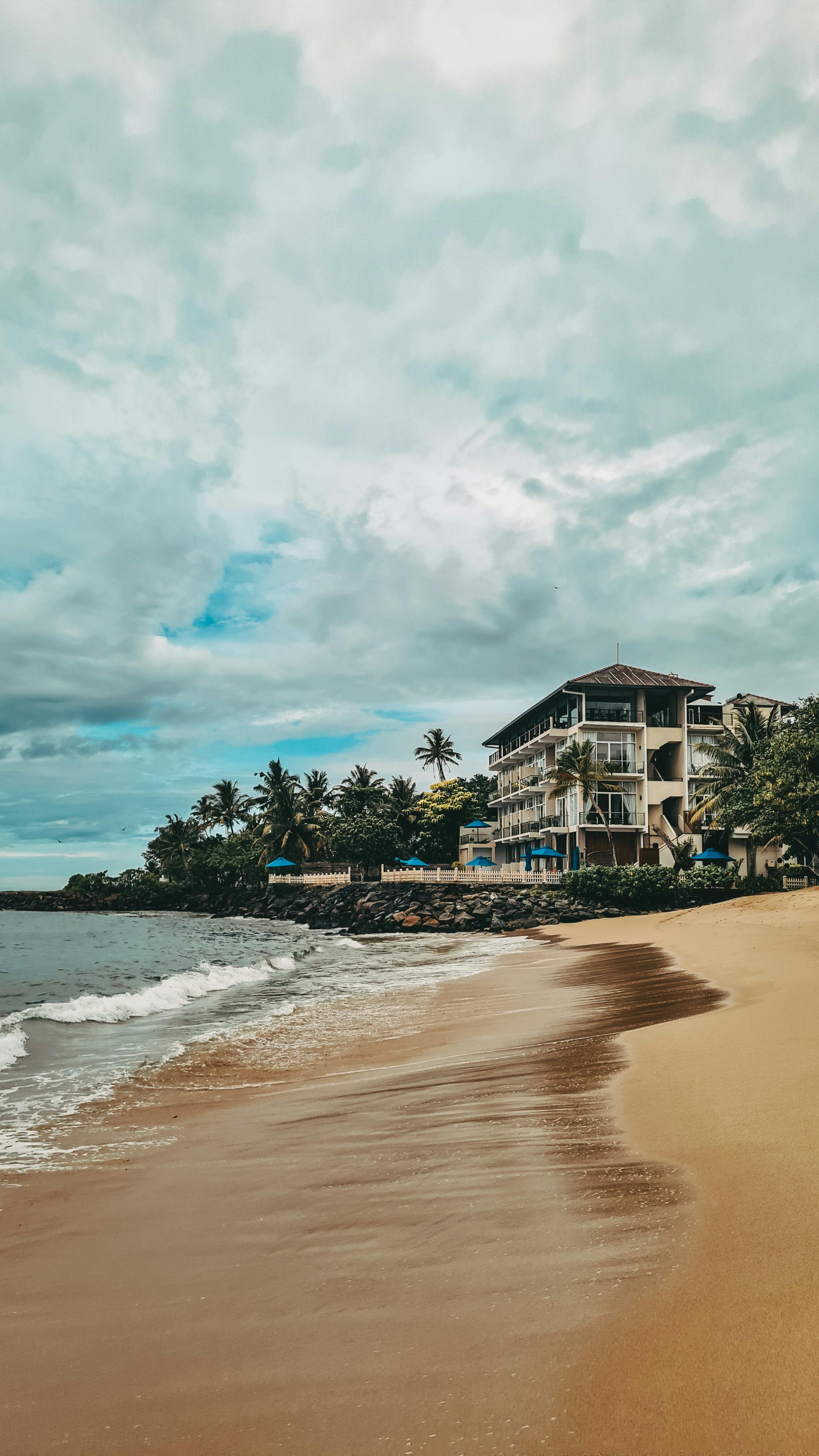 Woman in a light suit sitting thoughtfully against a terracotta wall