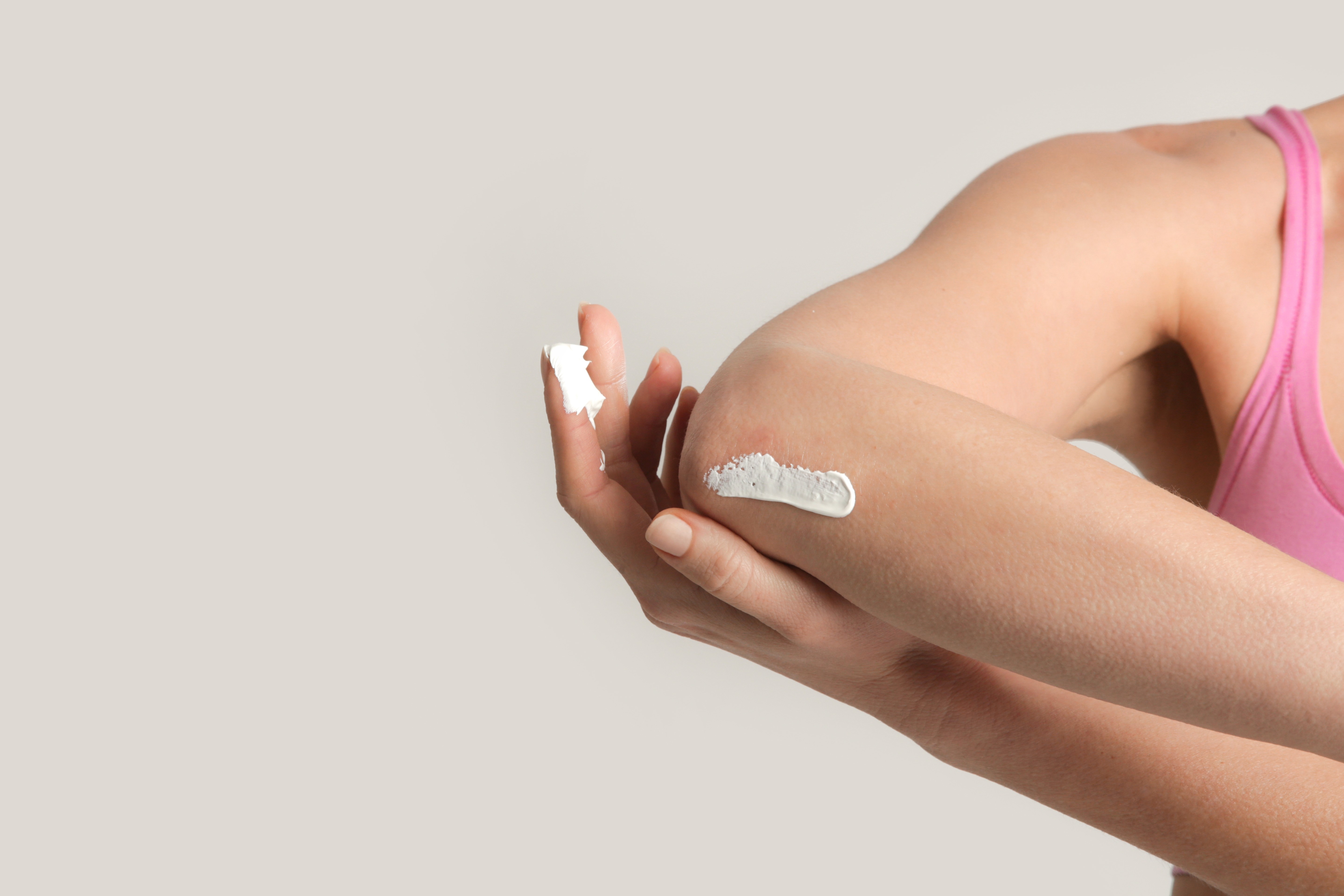 woman applying cream on elbow