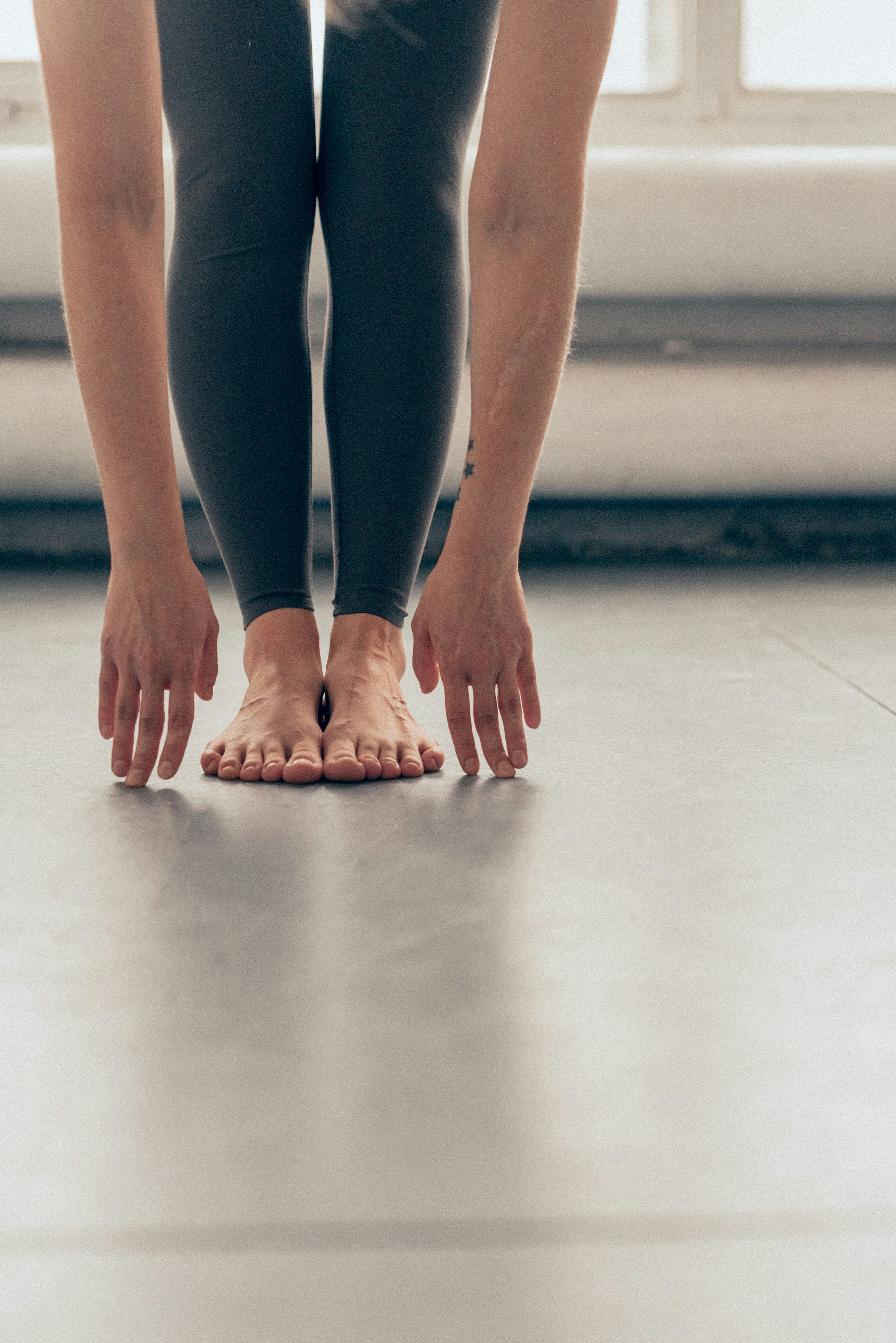 Um close-up dos pés de um praticante numa esteira de yoga, mostrando estabilidade e conexão com o chão